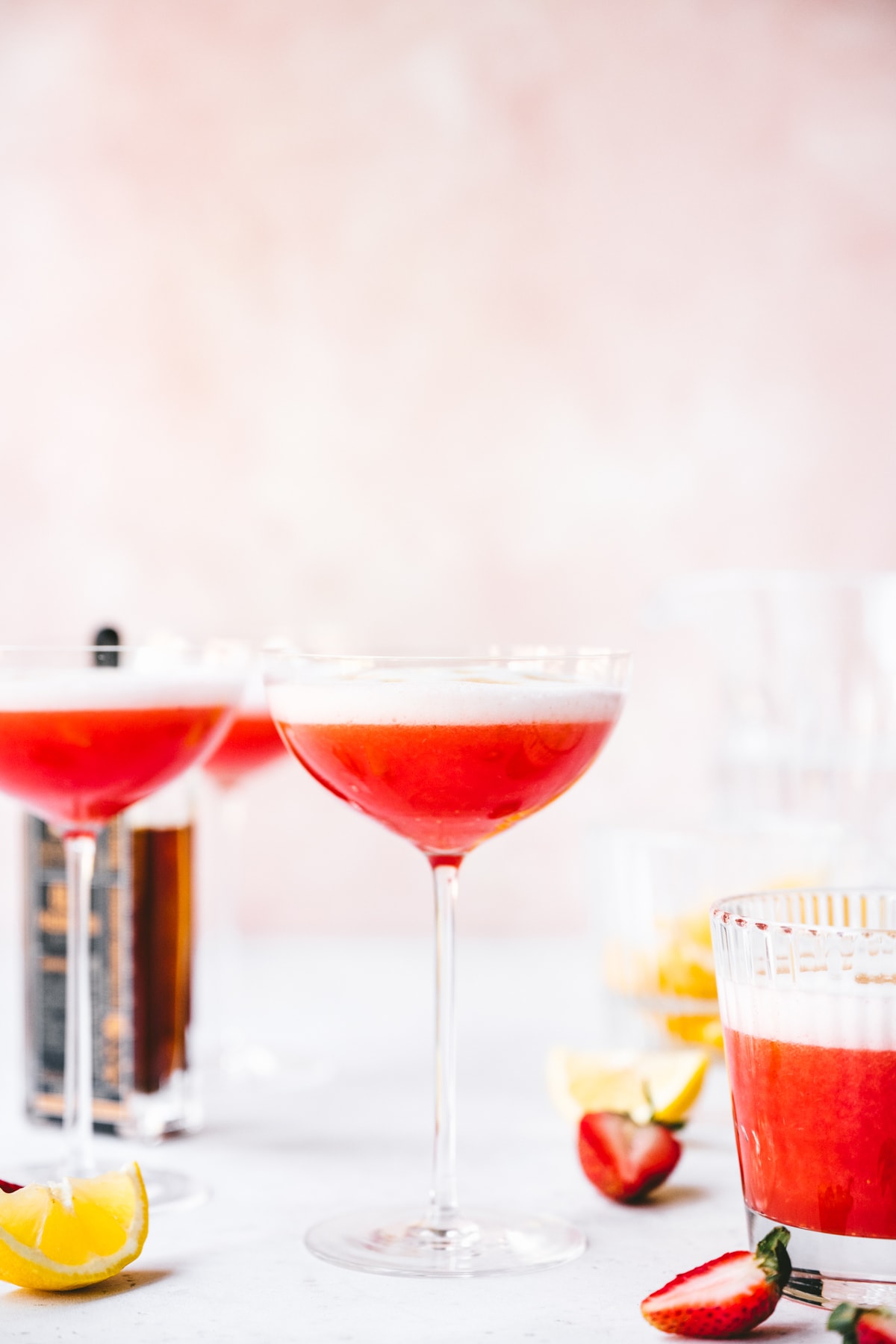 side view of vegan strawberry pisco sour in a coupe glass