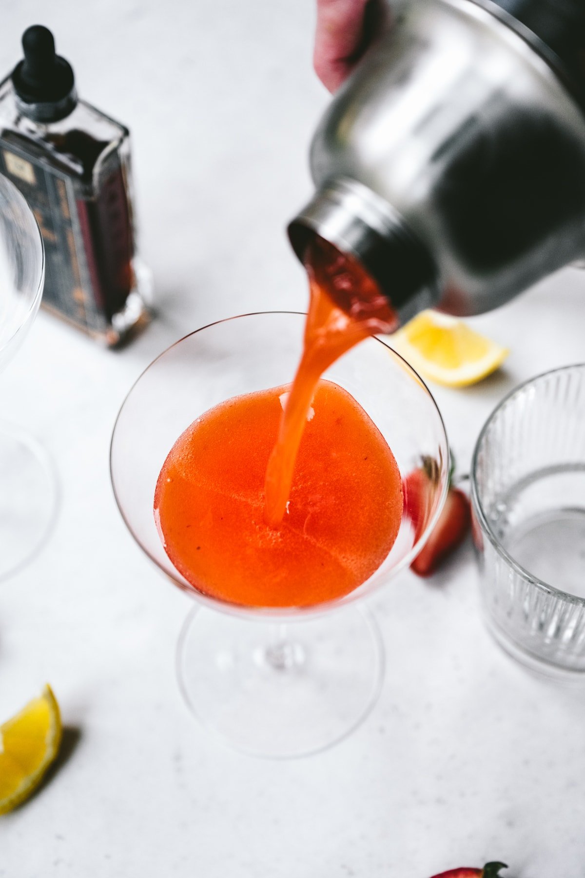 pouring pisco sour into glass