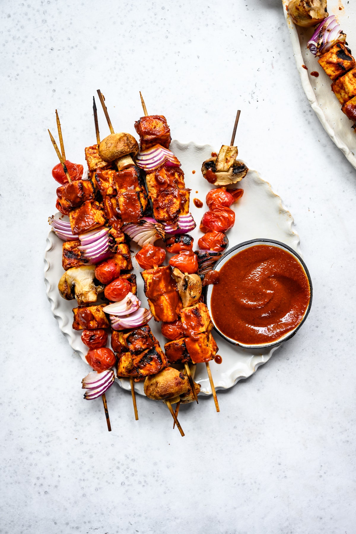 overhead view of grilled tofu kebabs on a white plate