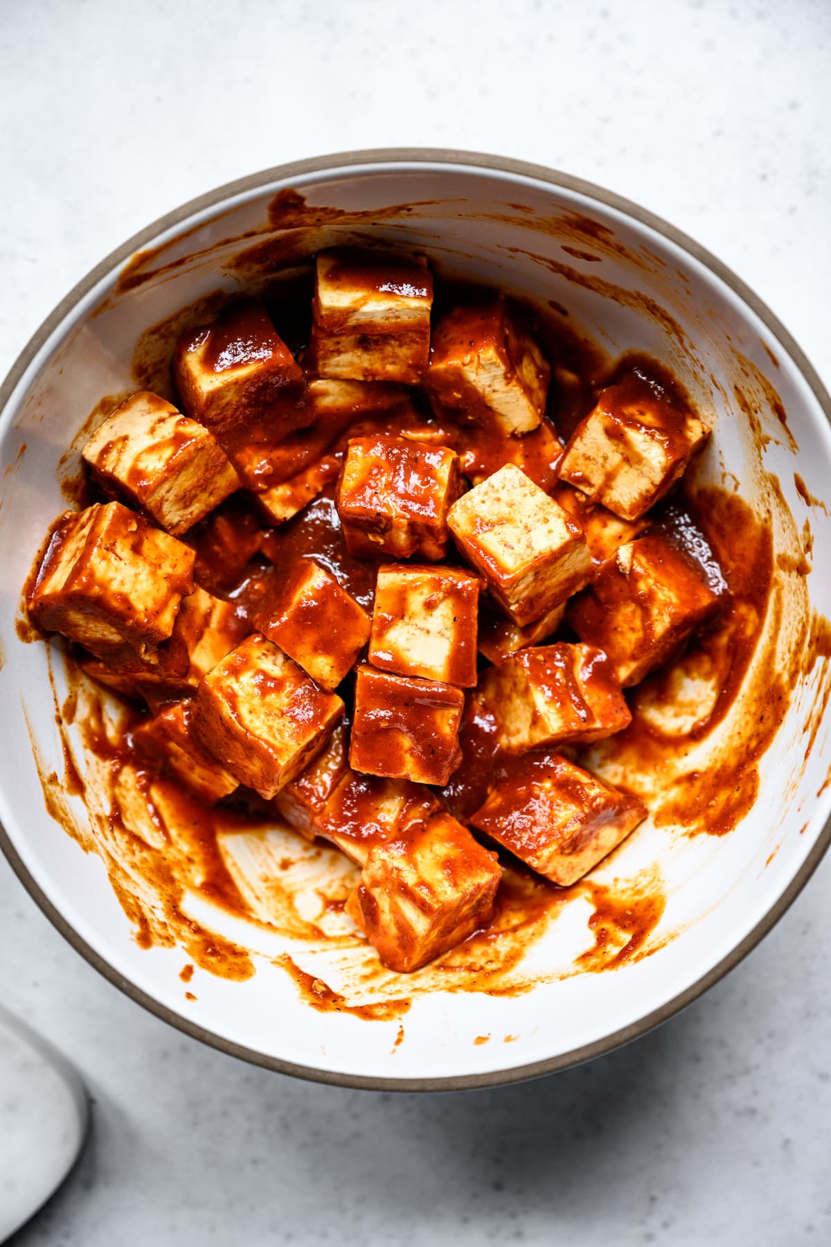 overhead view of tofu cubes in barbecue marinade