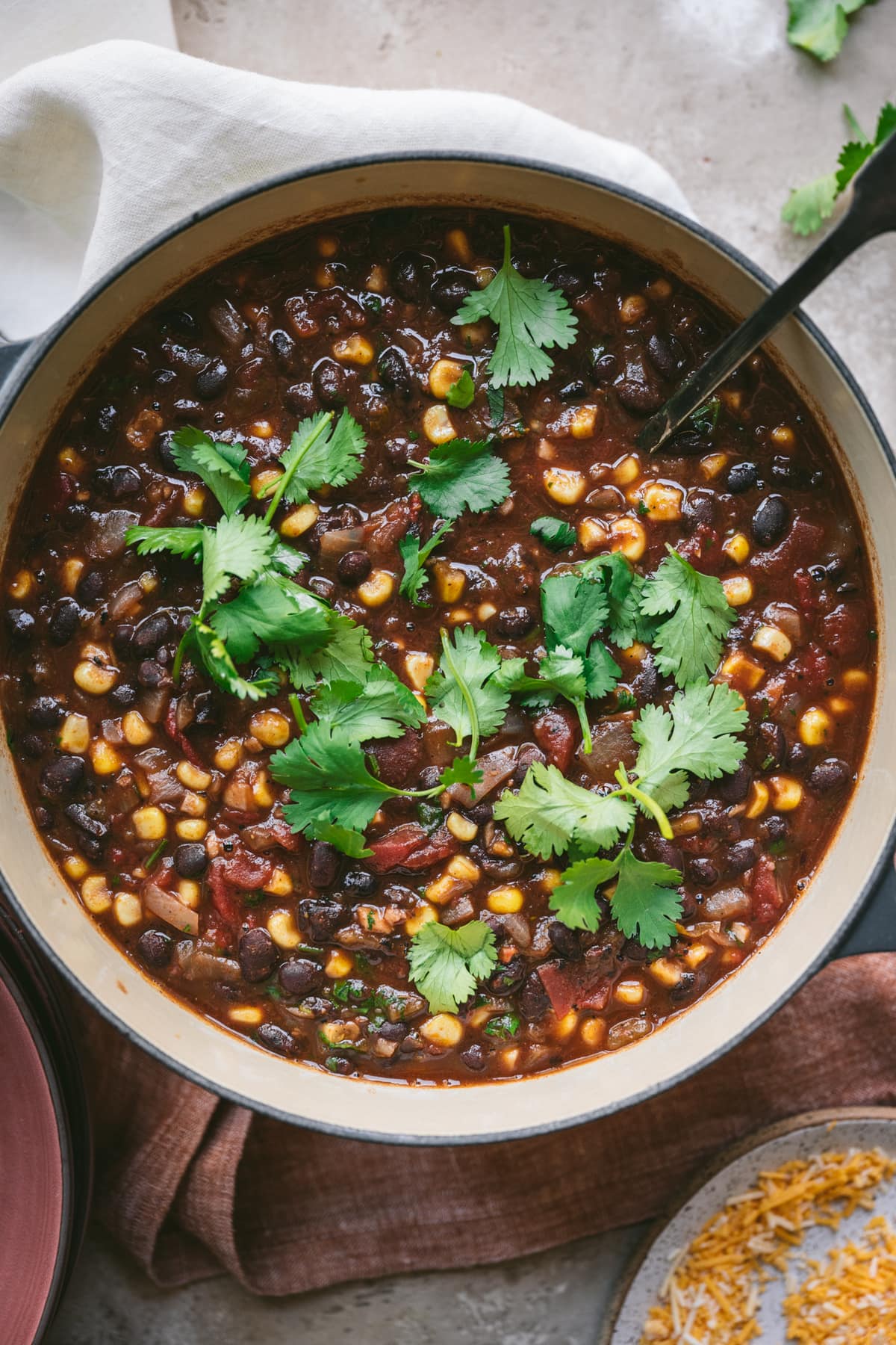 overhead view of vegan black bean corn soup in pot with cilantro