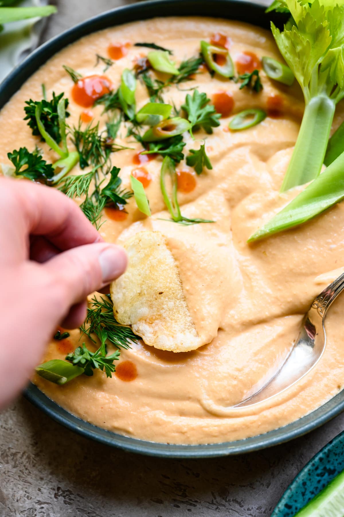 dipping chip into vegan buffalo white bean dip