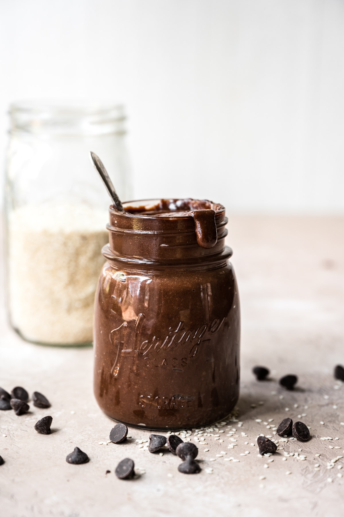 side view of homemade chocolate tahini in a glass jar