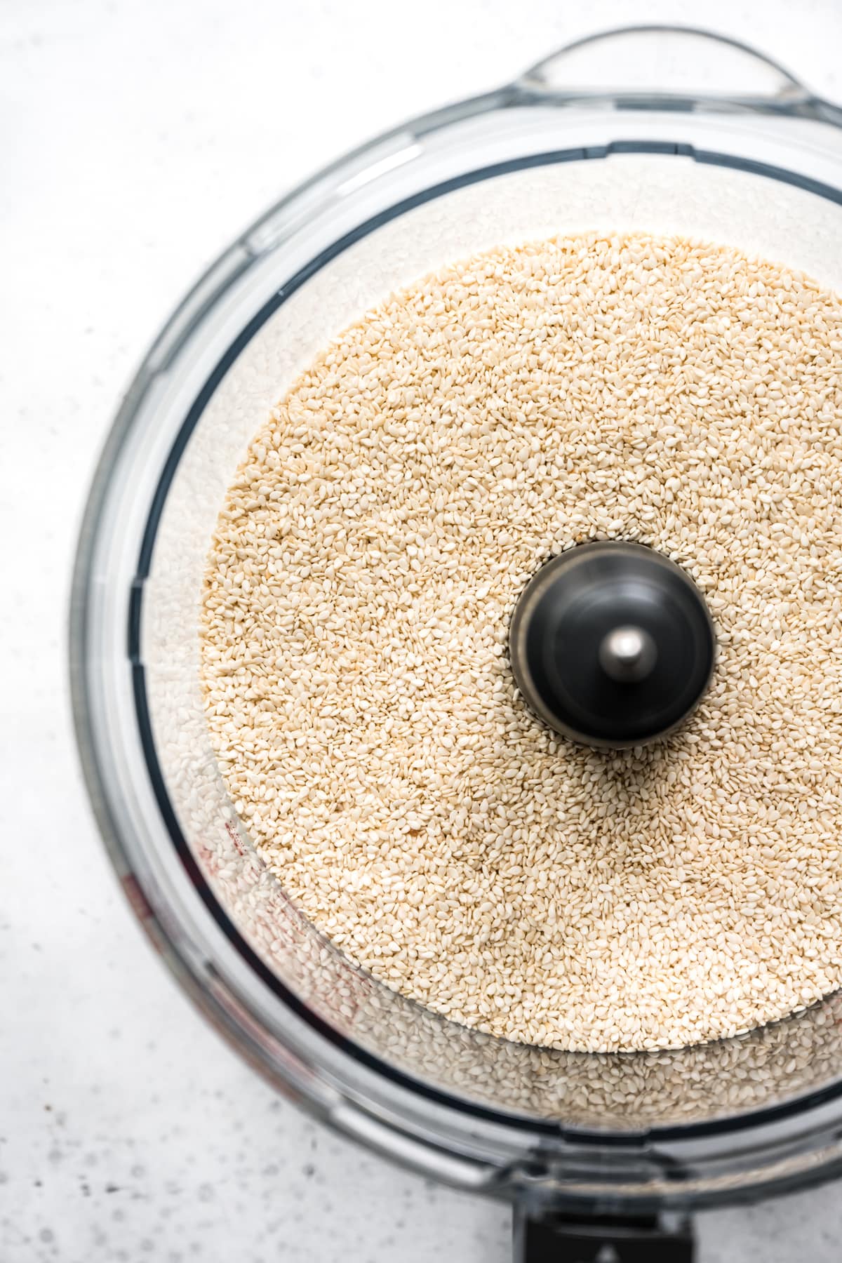 overhead view of hulled sesame seeds in food processor