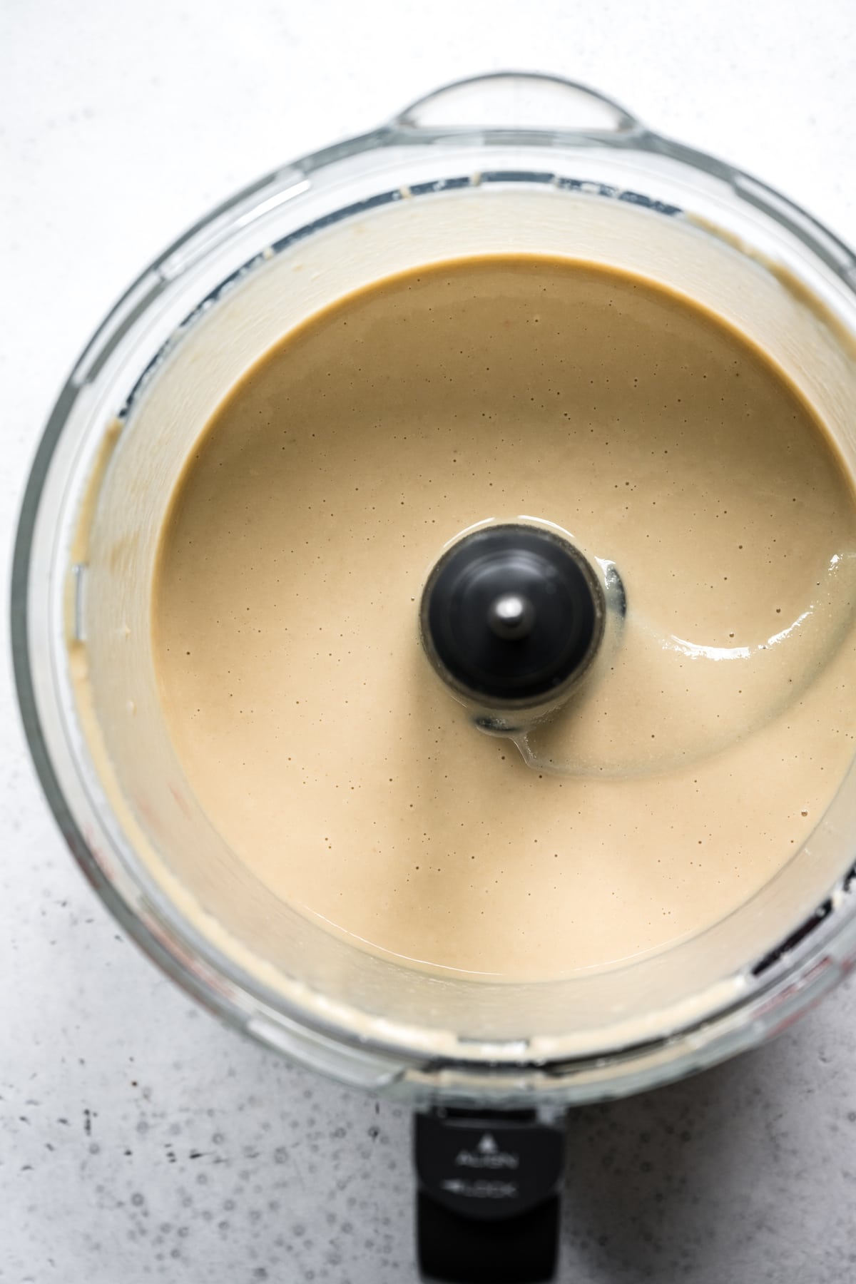 overhead view of creamy homemade tahini in food processor