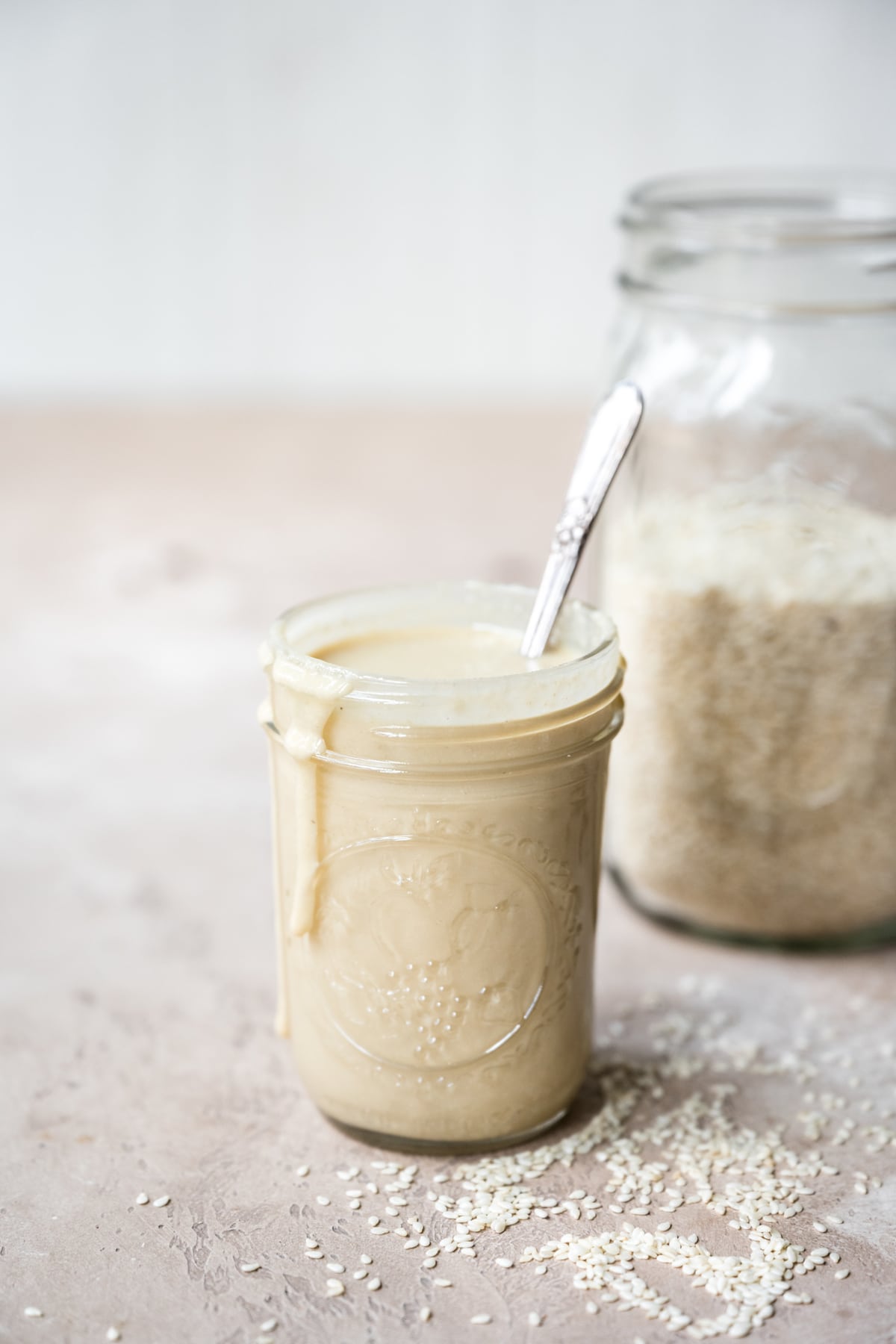 side view of homemade tahini in a glass jar