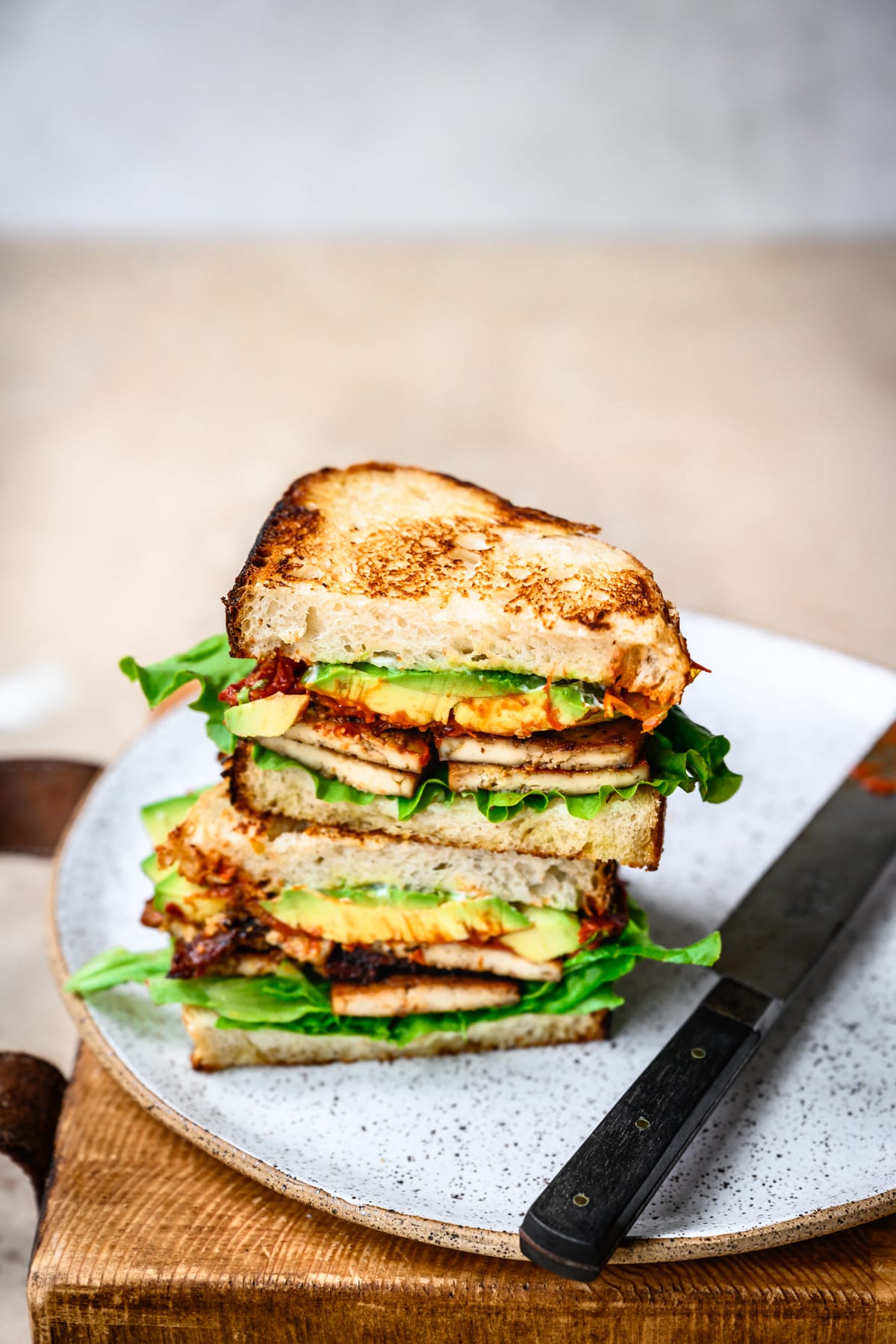 side view of vegan BLT with avocado cut in half and stacked