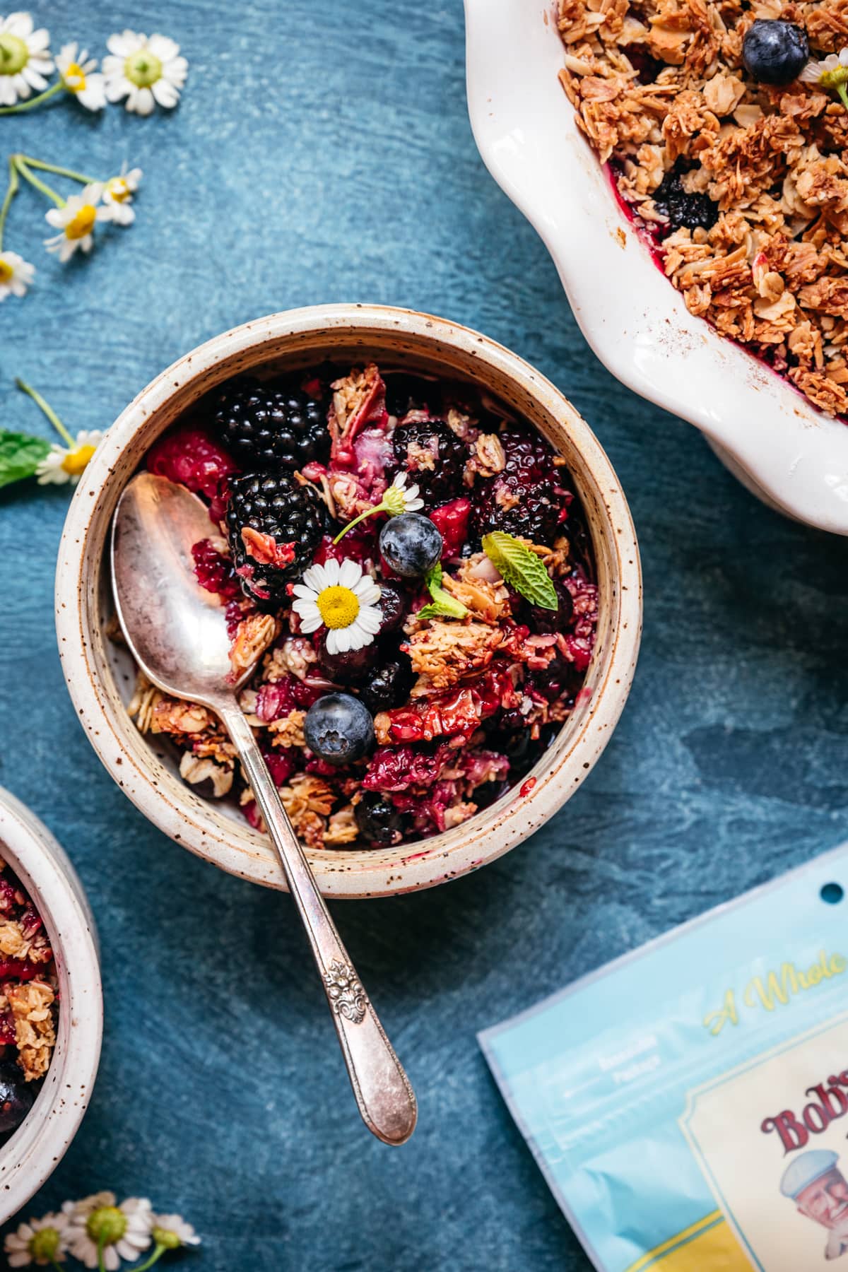 triple berry granola crisp in a small bowl with spoon