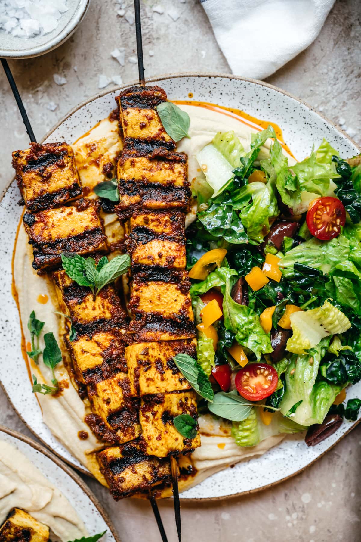 Mediterranean tofu kebabs over hummus with a salad