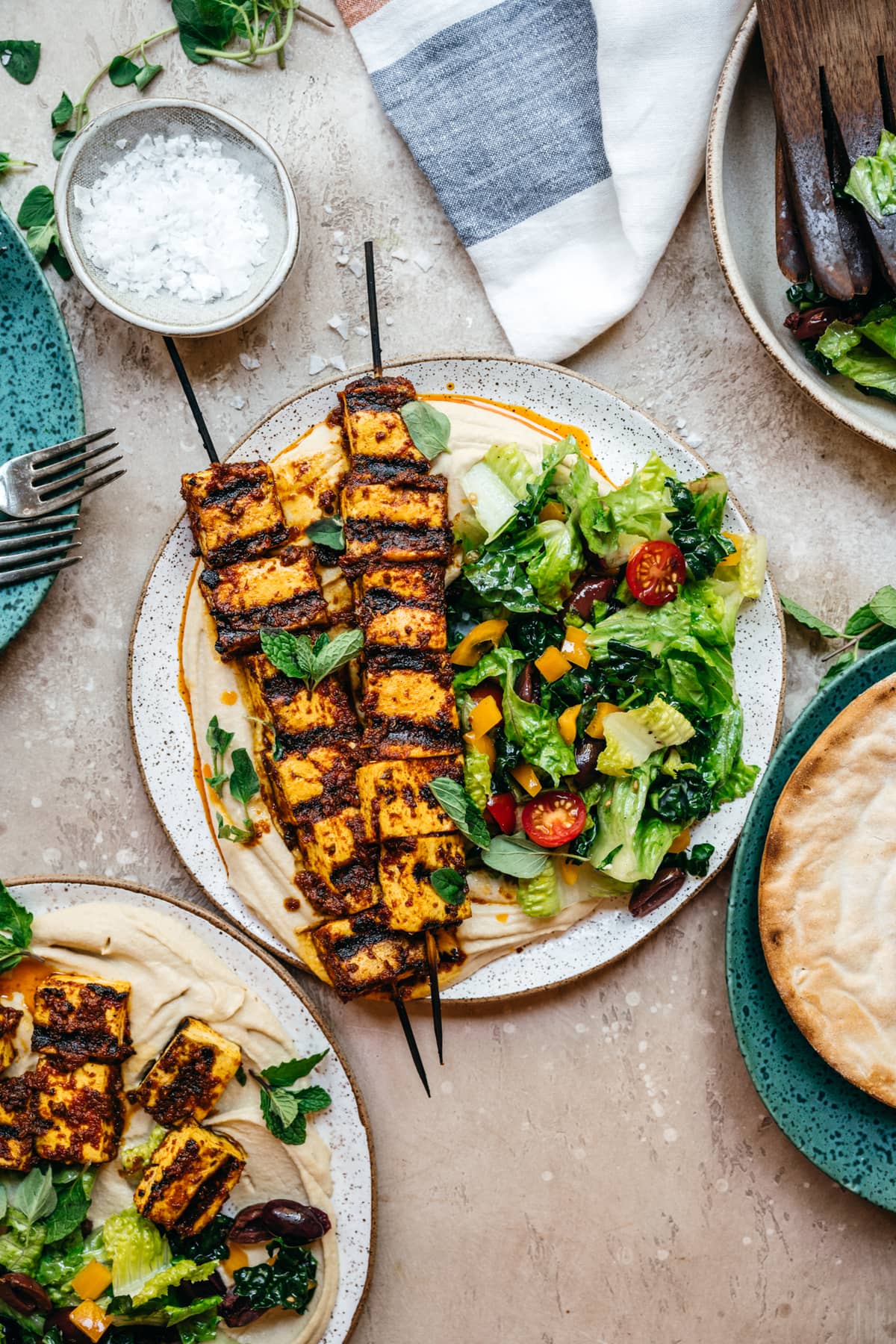 Mediterranean tofu kebabs over hummus with a salad