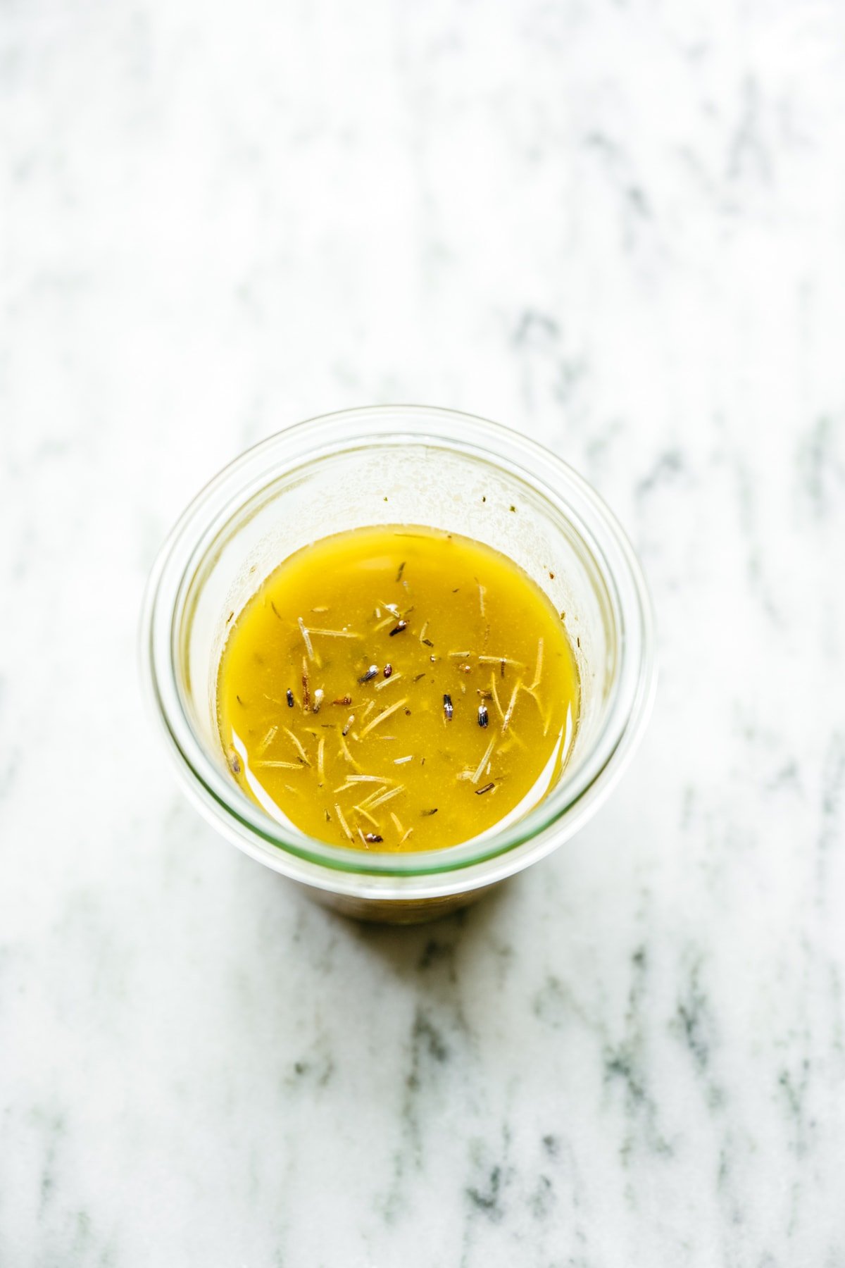 creamy dijon herb dressing in a glass jar on marble