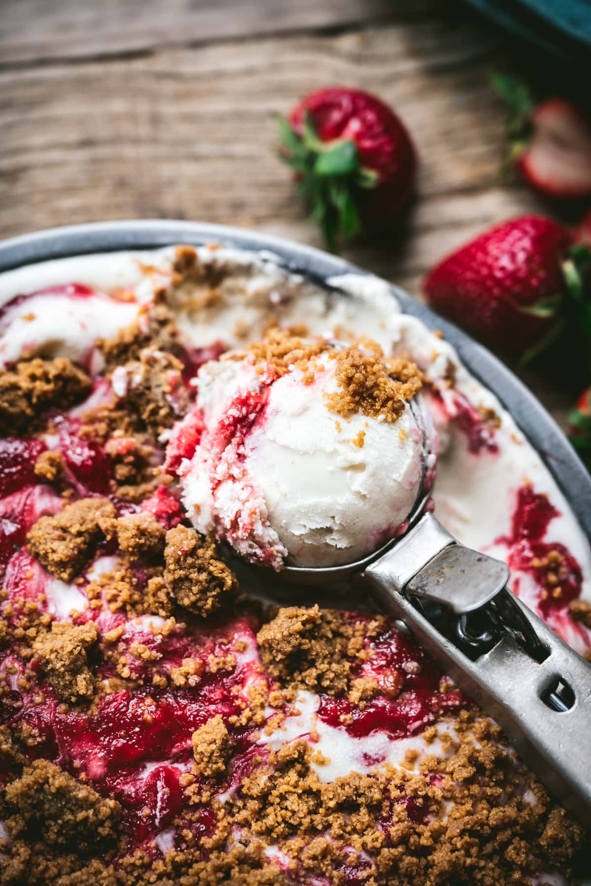 close up view of vegan strawberry cheesecake ice cream on ice cream scoop