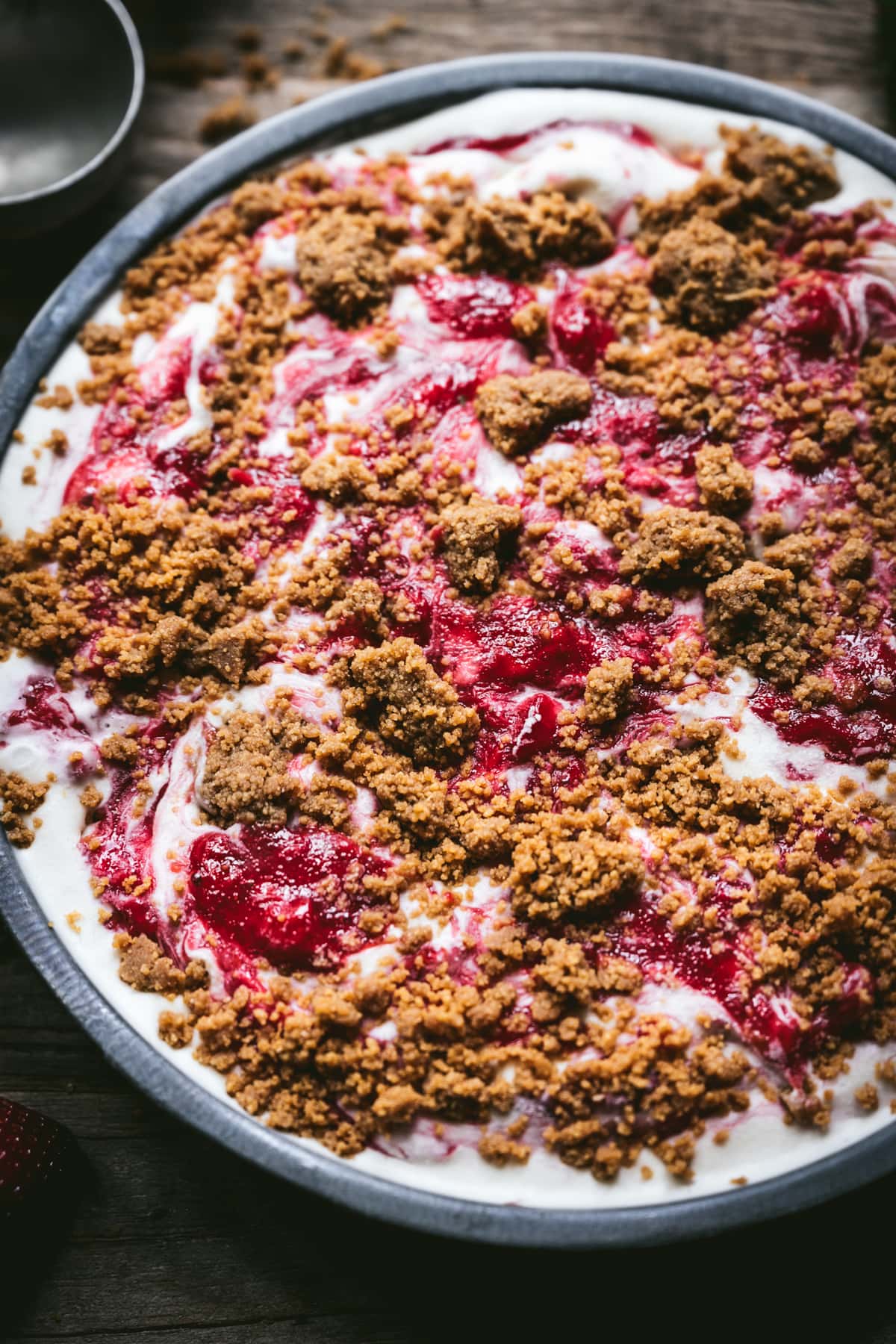 close up view of strawberry cheesecake ice cream with graham cracker streusel