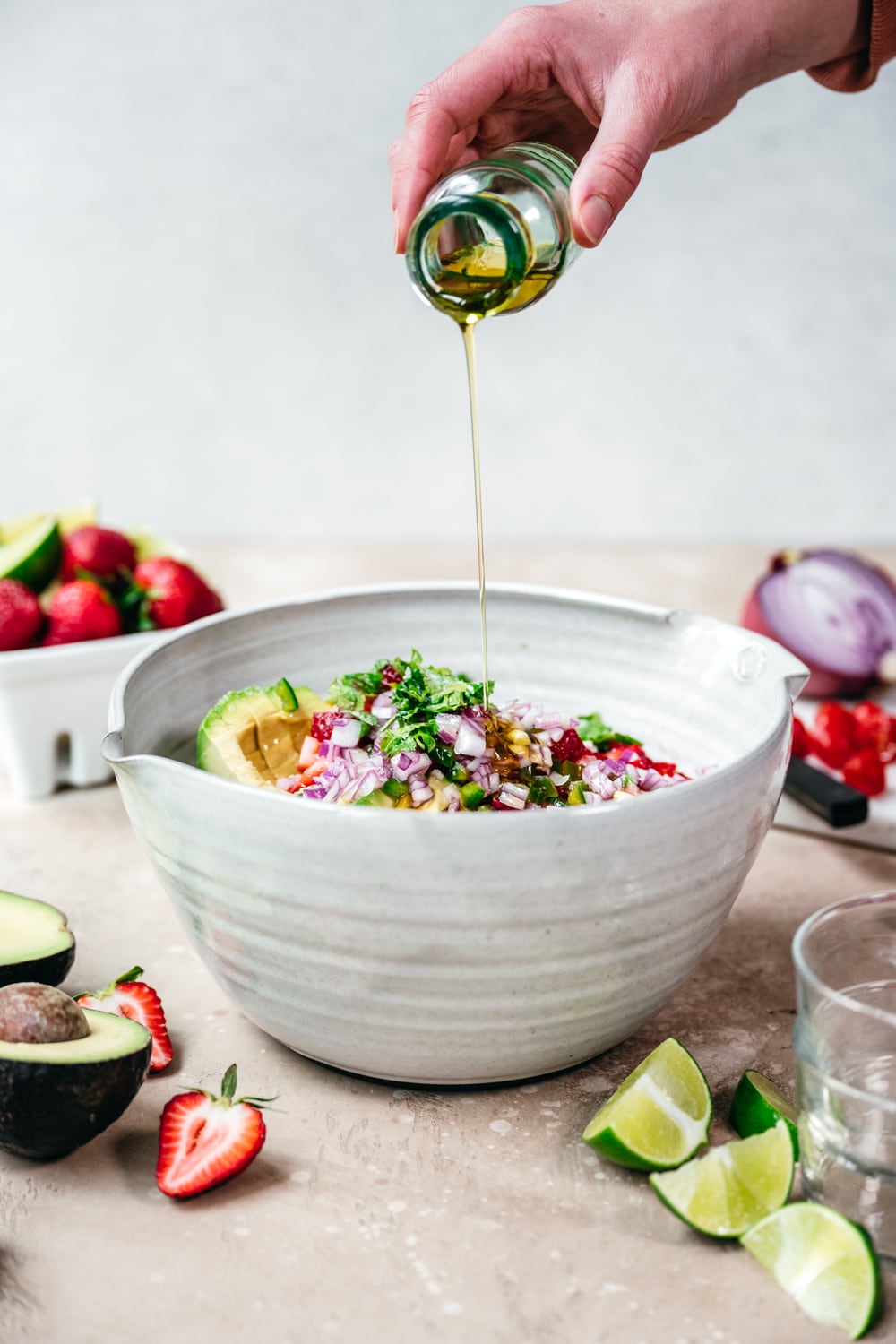pouring olive oil into a bowl with vegan ceviche ingredients