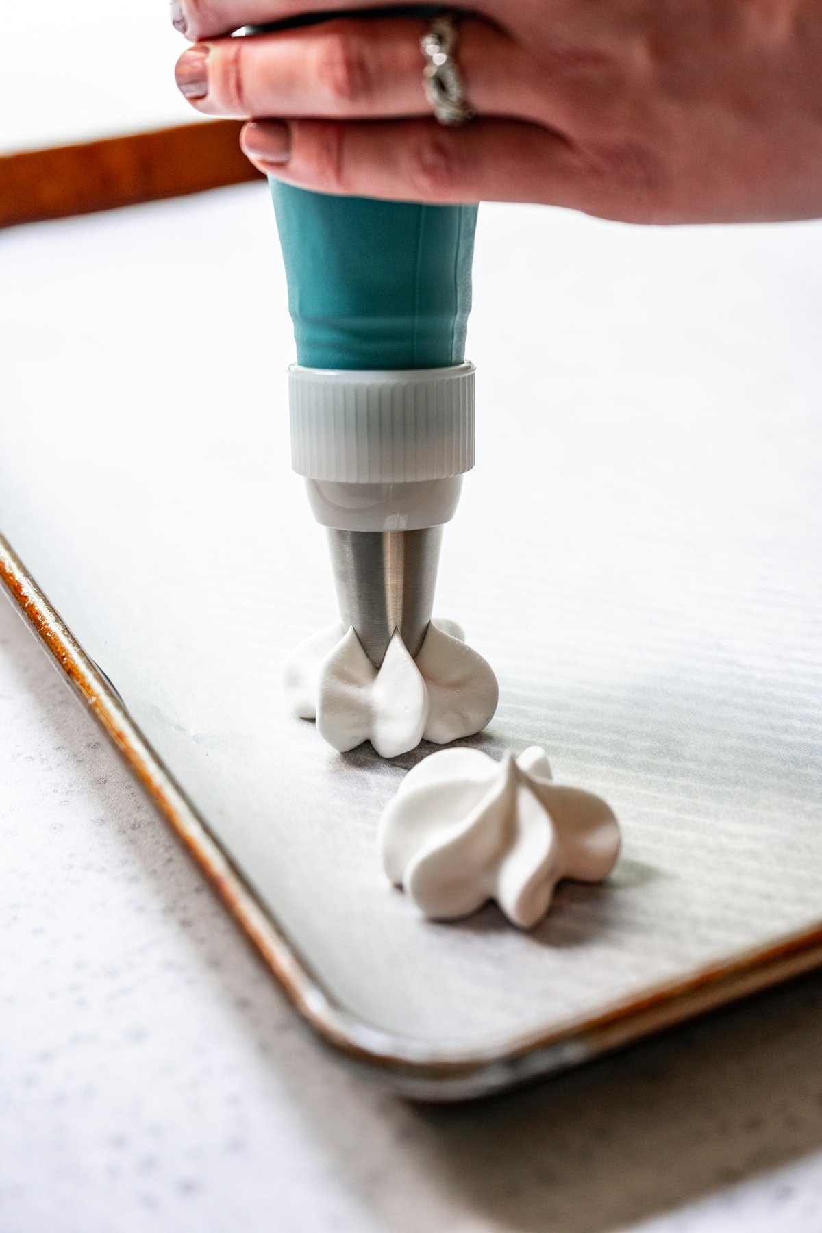 piping vegan meringues onto parchment paper