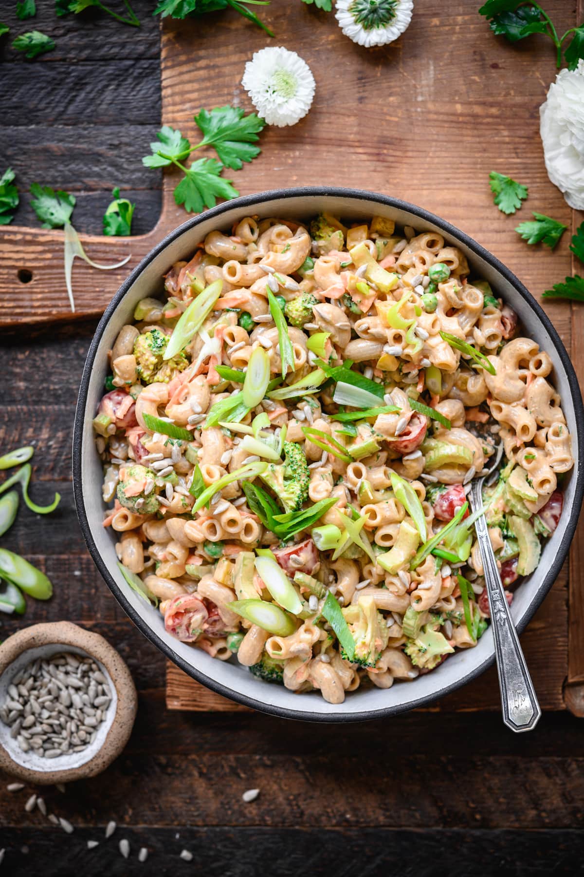 overhead view of vegan macaroni salad in a bowl with fresh vegetables