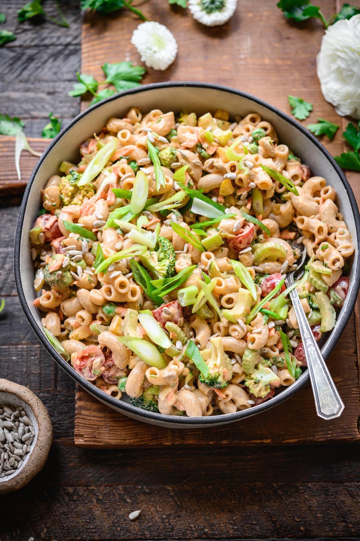 overhead view of vegan macaroni salad in a bowl with fresh vegetables