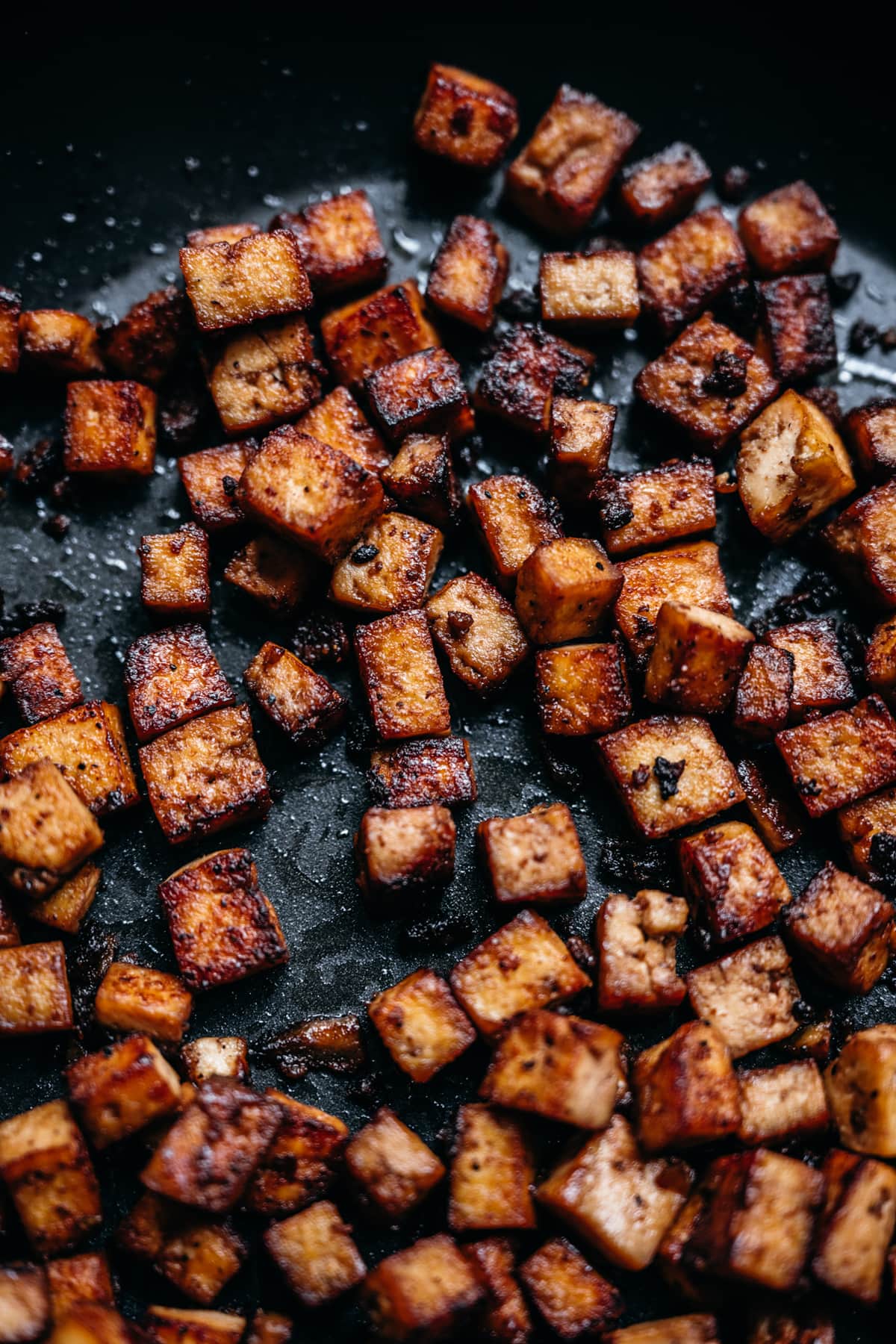 close up view of vegan tofu bacon bites in a pan.