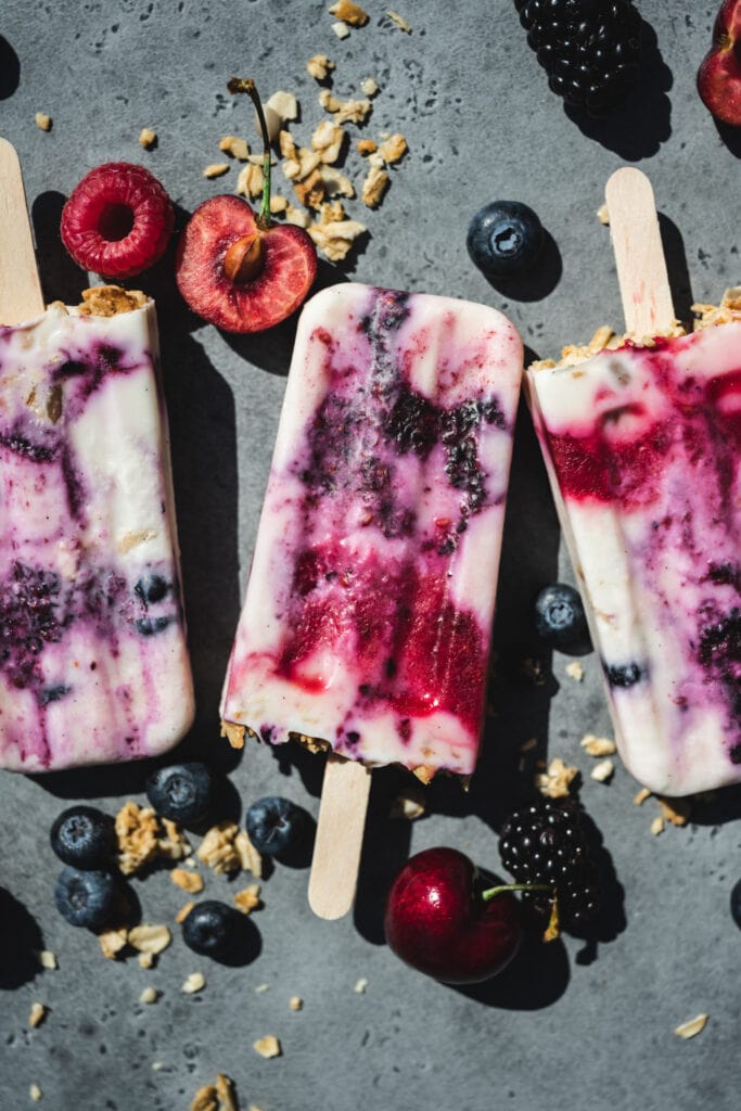 overhead view of vegan yogurt berry breakfast popsicles with berries