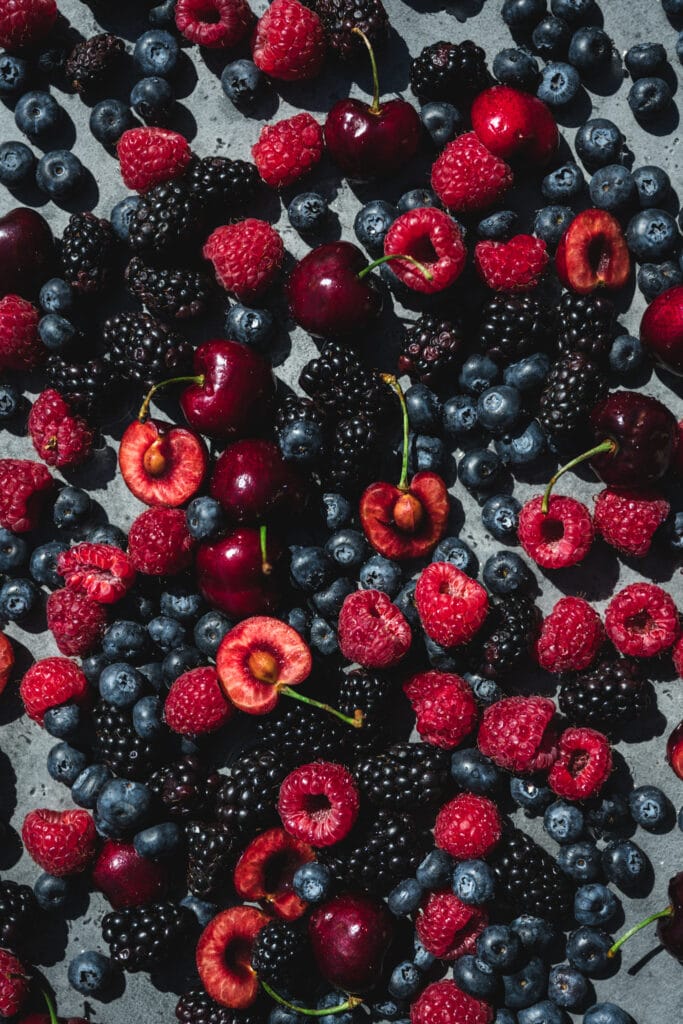 overhead view of mixed fresh berries in direct sunlight