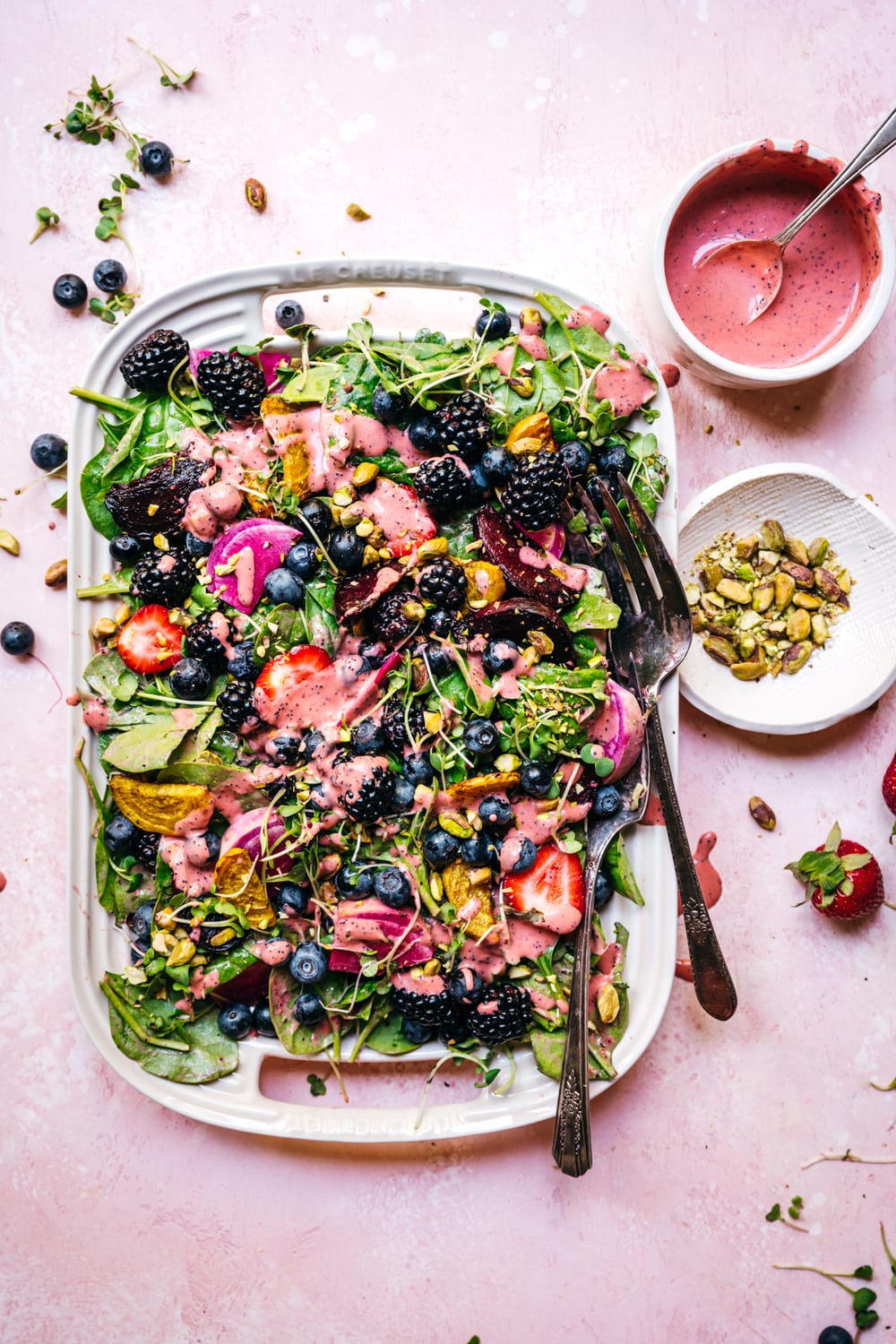 overhead view of roasted beet berry salad with strawberry poppy seed dressing on a platter