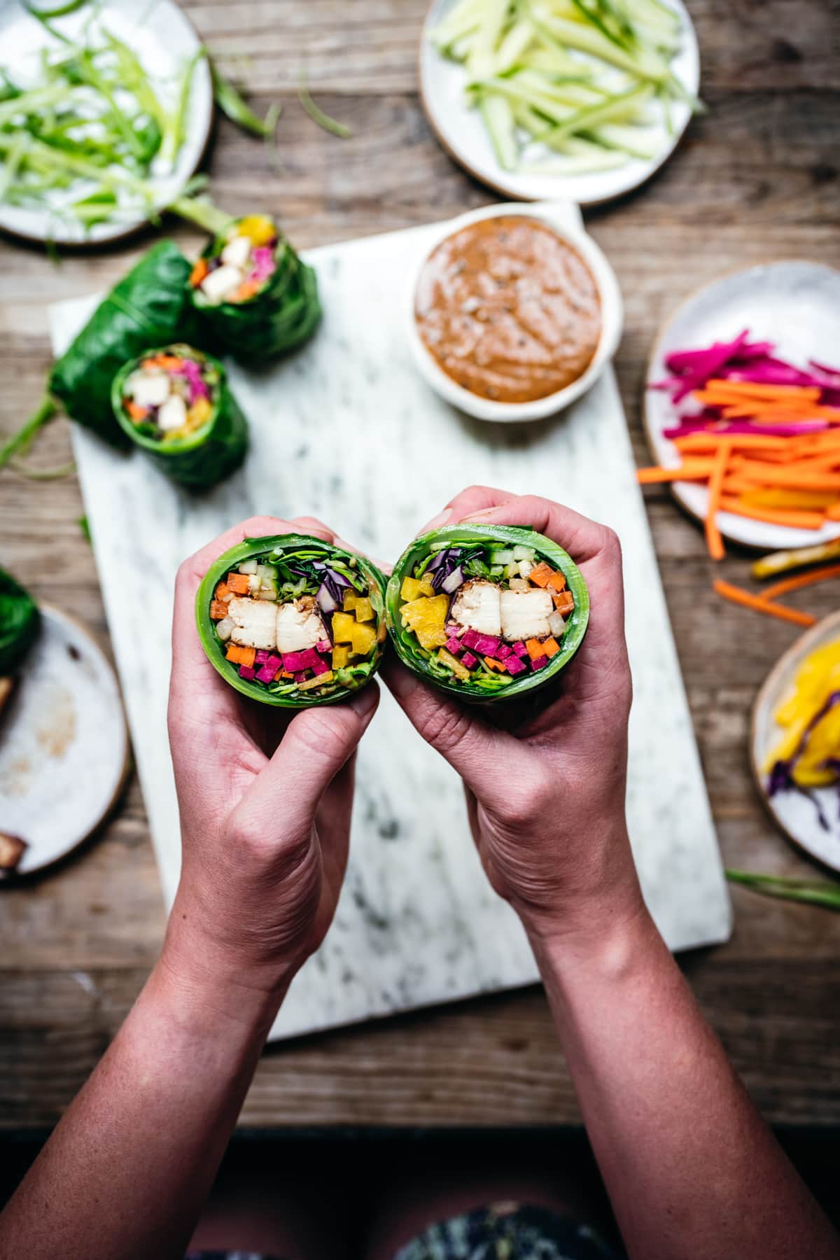 overhead view of vegan collard green wraps with vegetables and tofu cut in half 