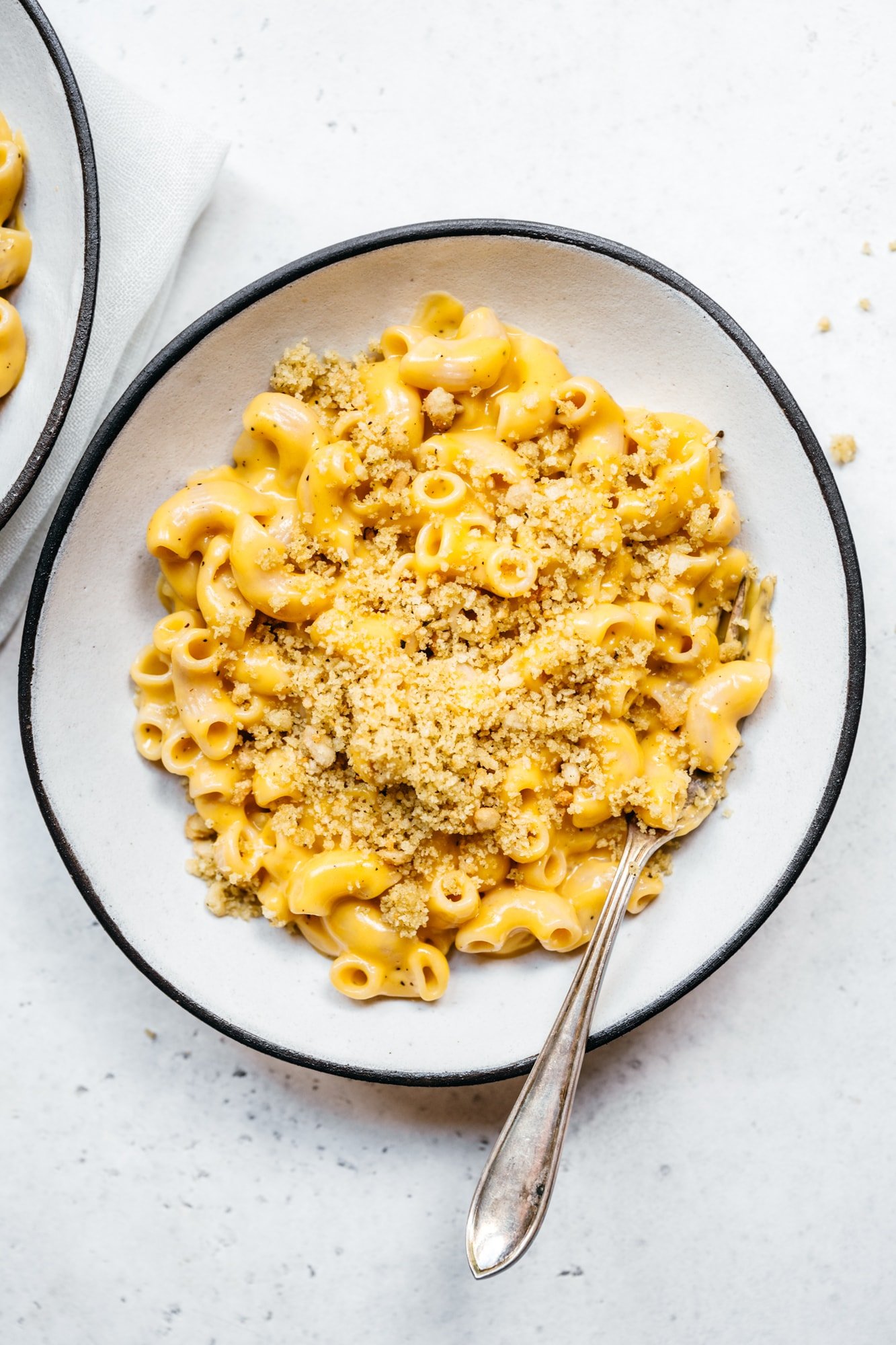 overhead view of easy vegan mac and cheese with breadcrumbs in white bowl