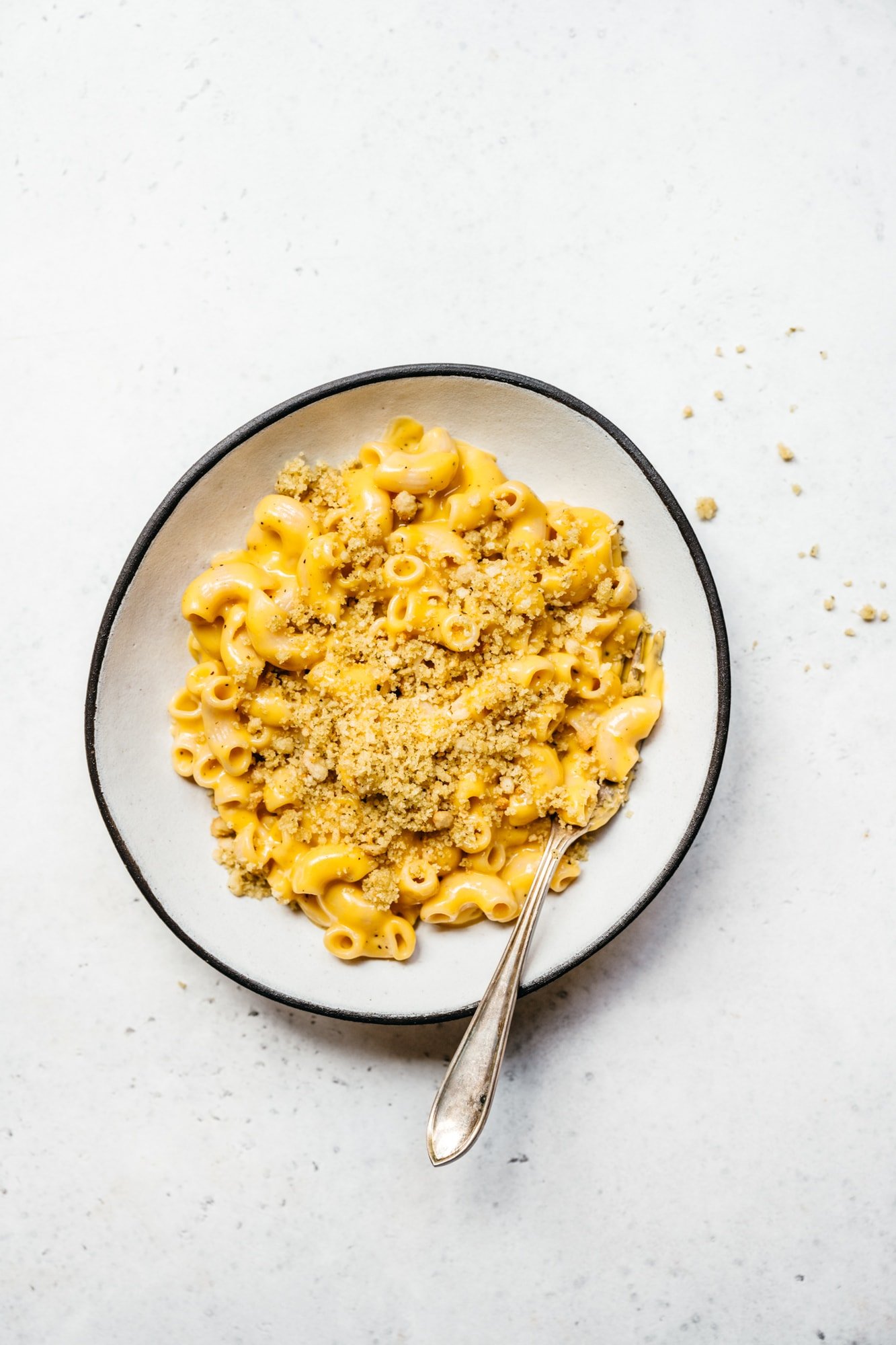 overhead view of easy vegan mac and cheese with breadcrumbs in white bowl