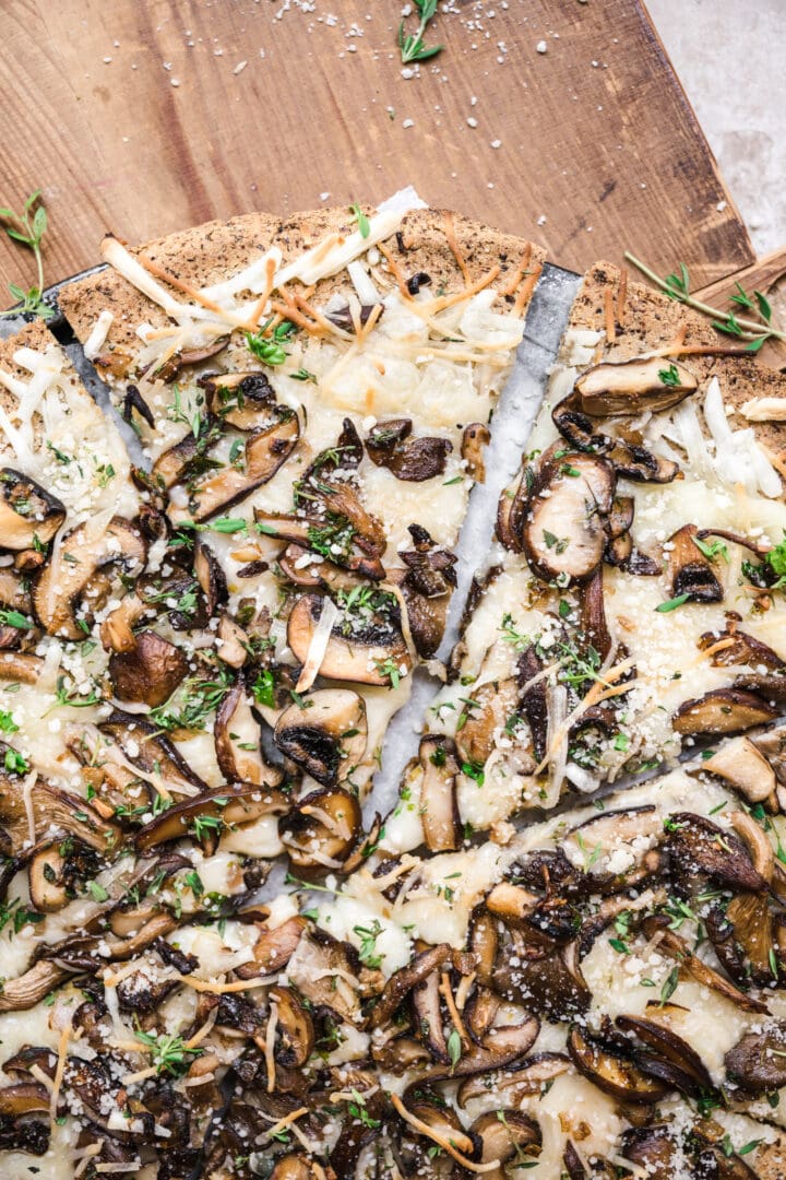 overhead view of slice of vegan mushroom pizza on cauliflower crust