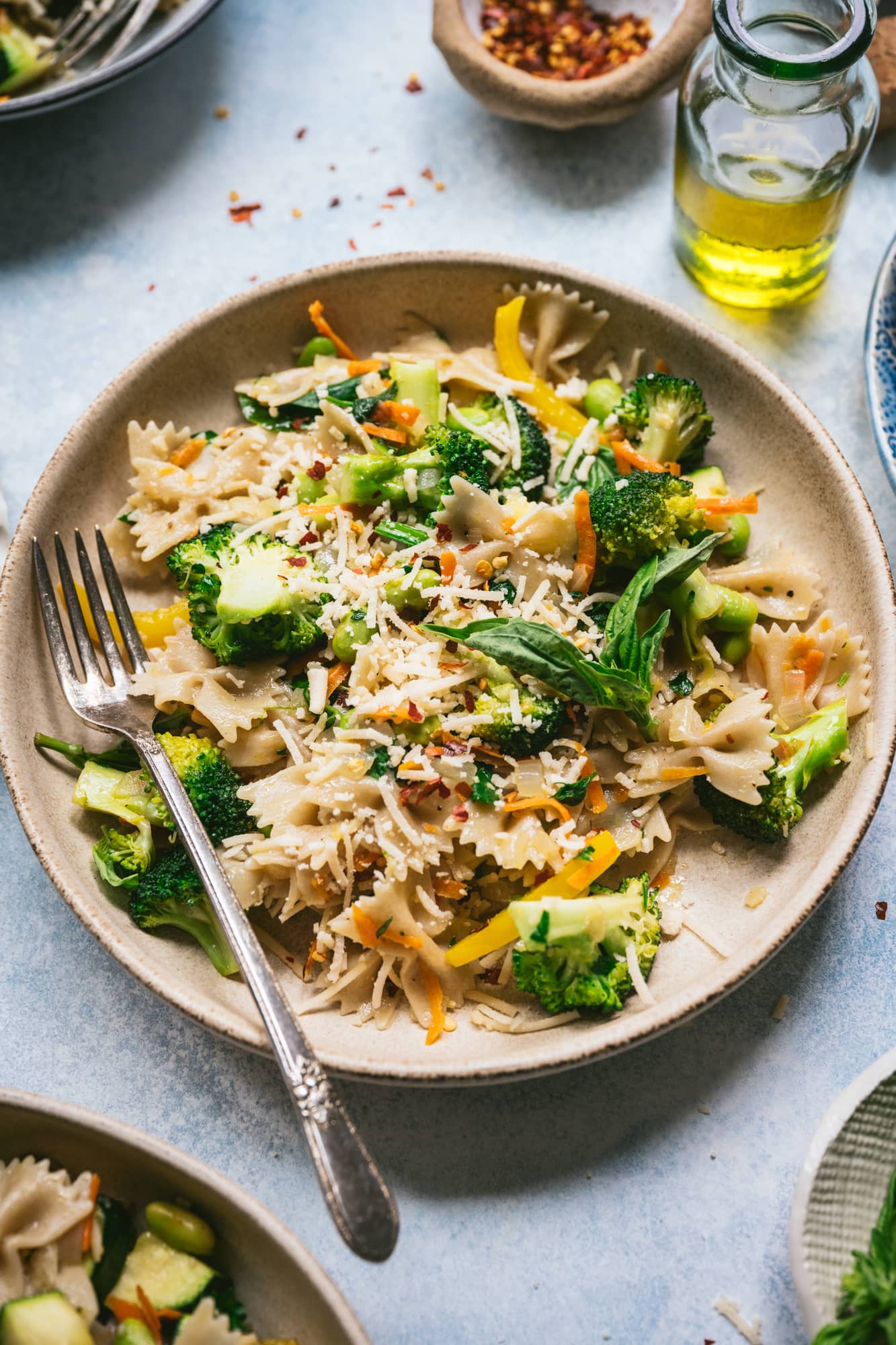 side view of vegan pasta primavera in a bowl with fork 