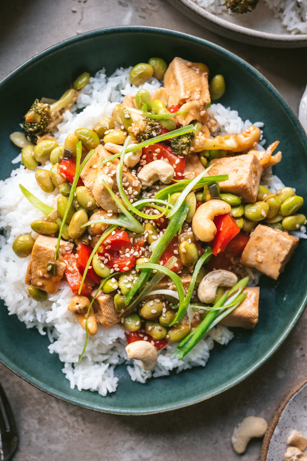 overhead view of pineapple teriyaki tofu served over rice in blue bowl