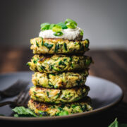 side view of stack of vegan zucchini fritters on a plate