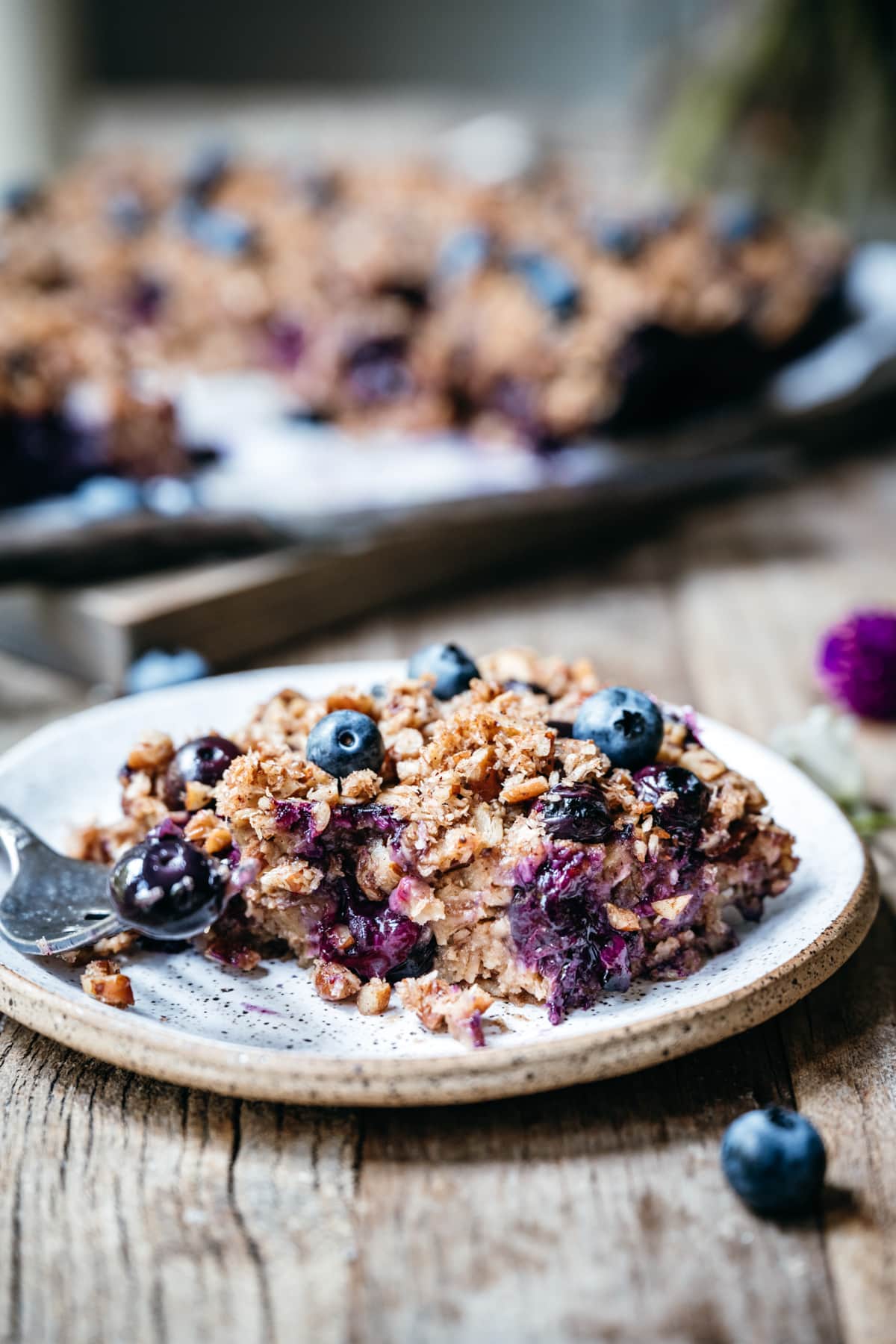 side view of slice of blueberry baked oatmeal on small plate