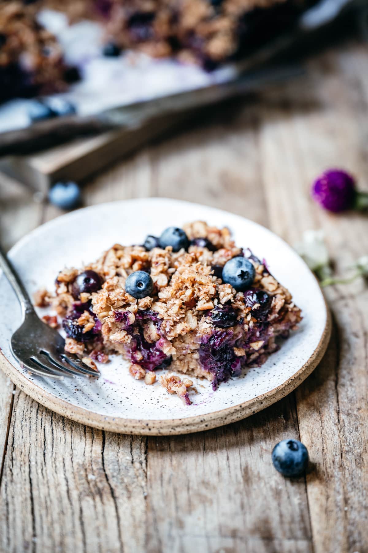side view of slice of blueberry baked oatmeal on small plate