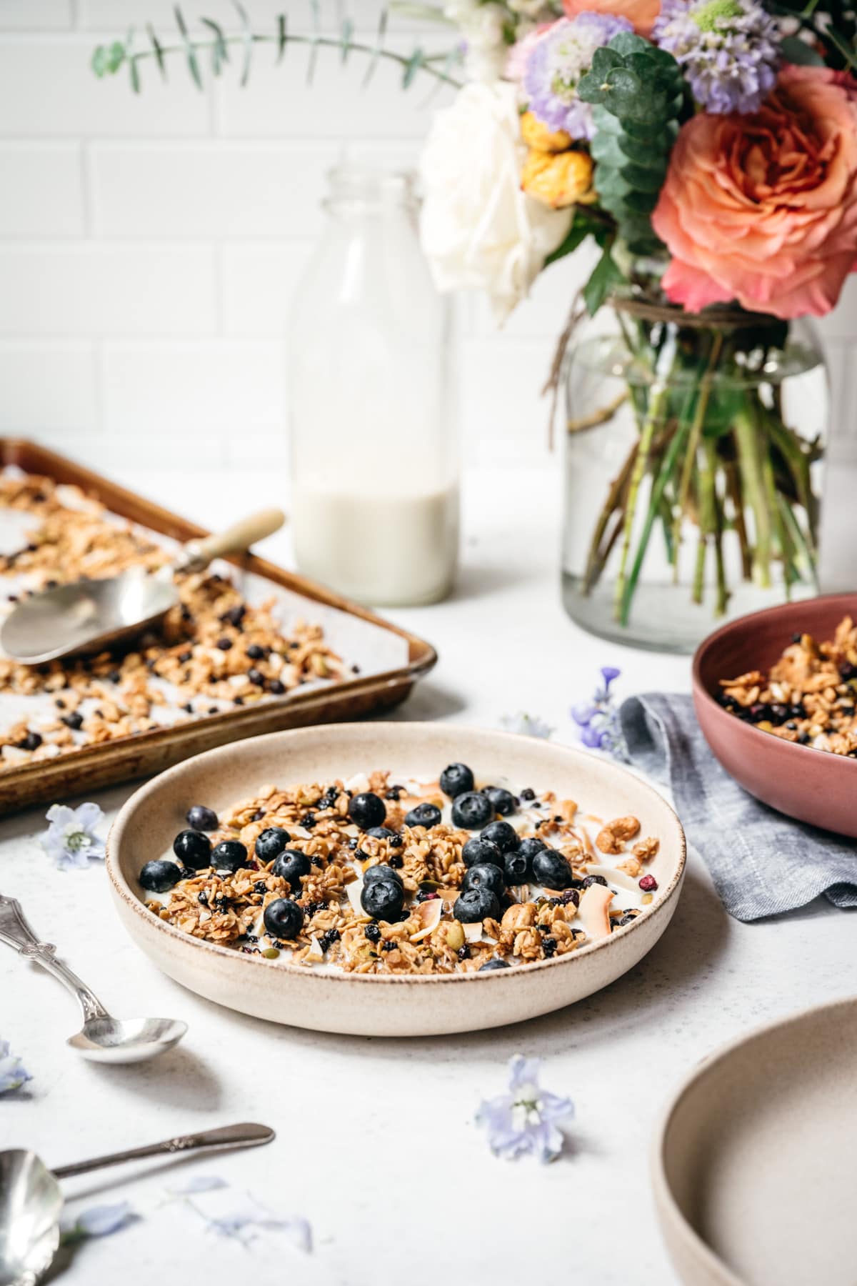 side view of blueberry lemon granola in a bowl with milk and blueberries