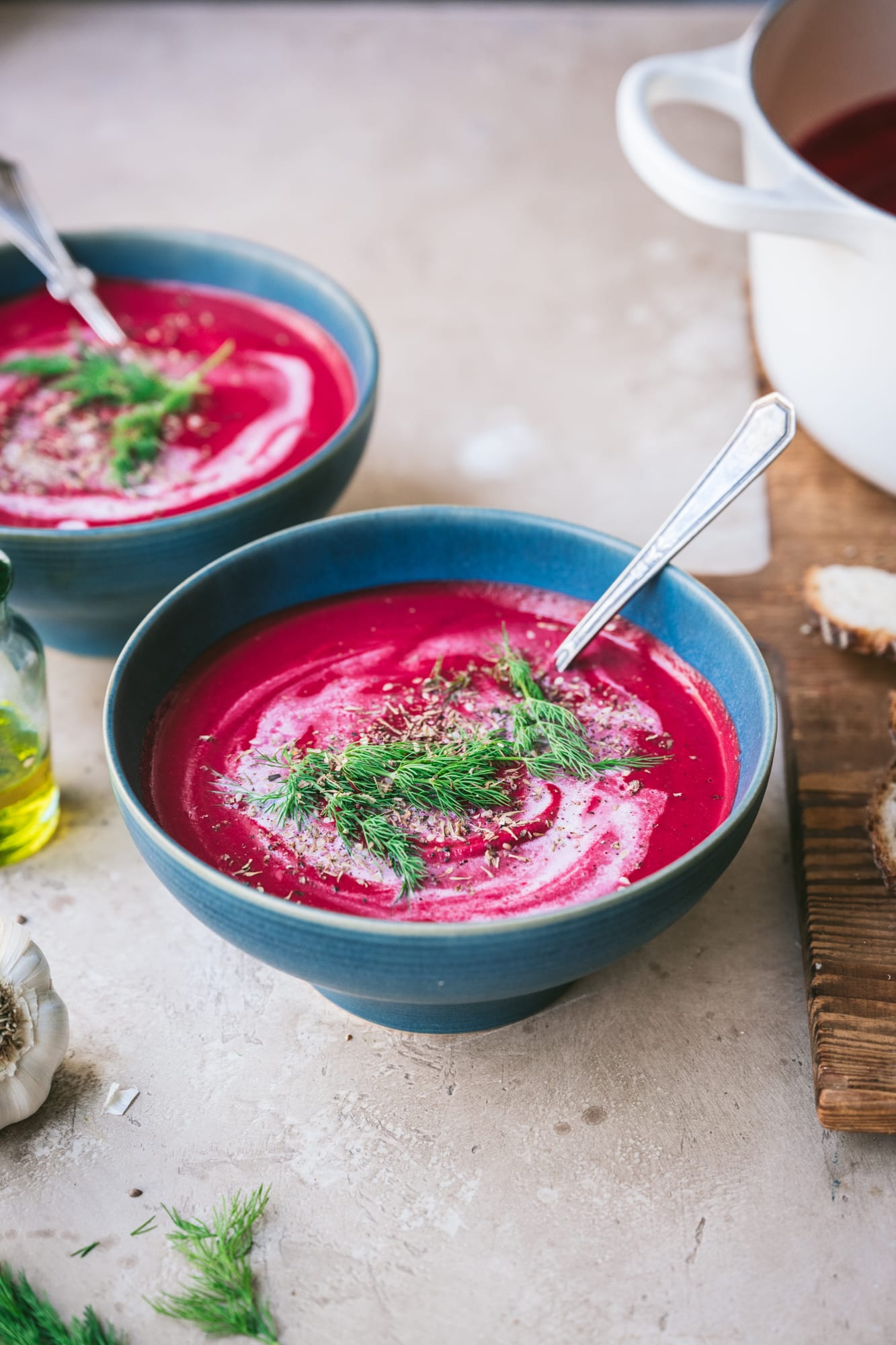 side view of vegan roasted beet soup in blue bowl with dill garnish