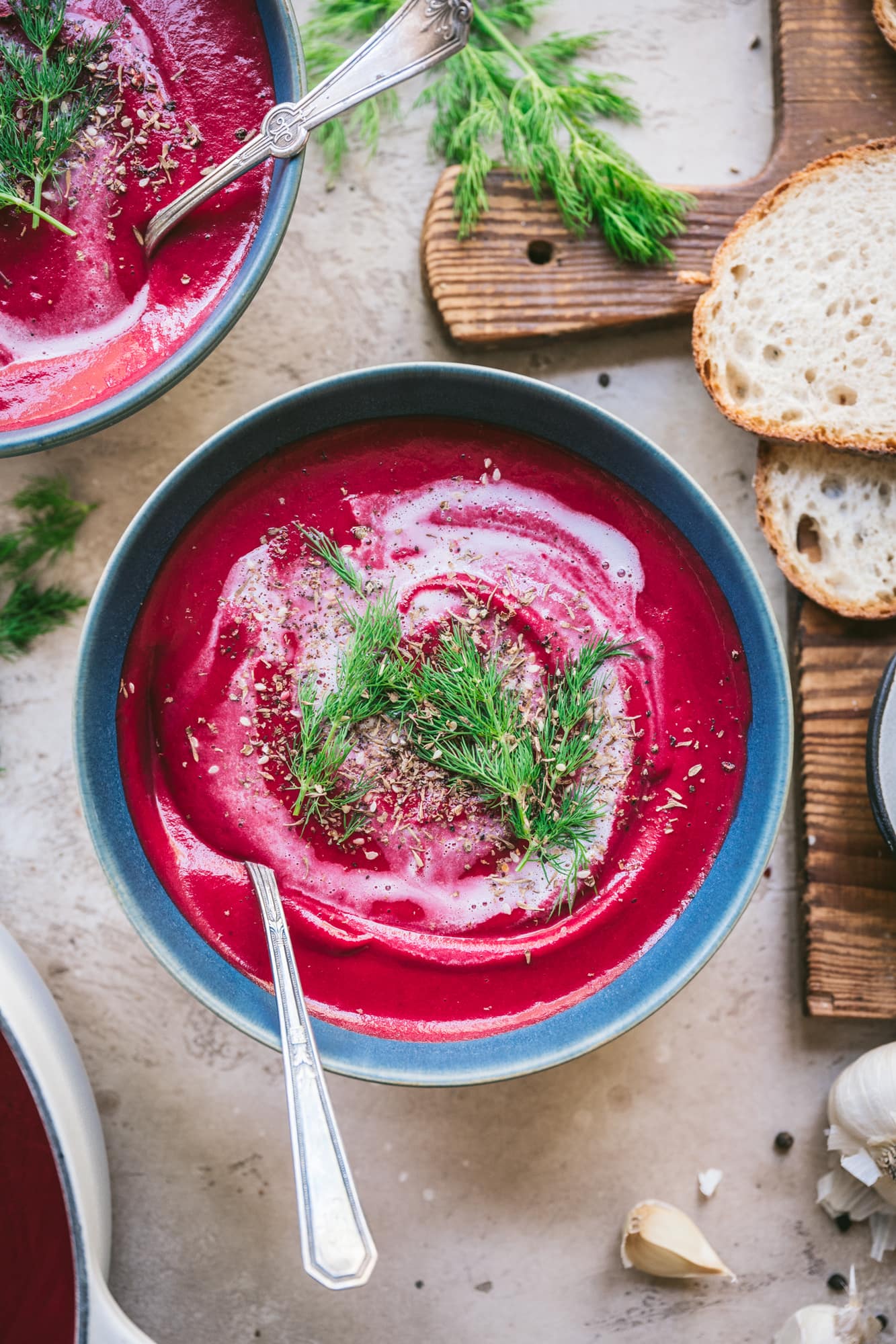 overhead view of vegan roasted beet soup with yogurt swirl and dill