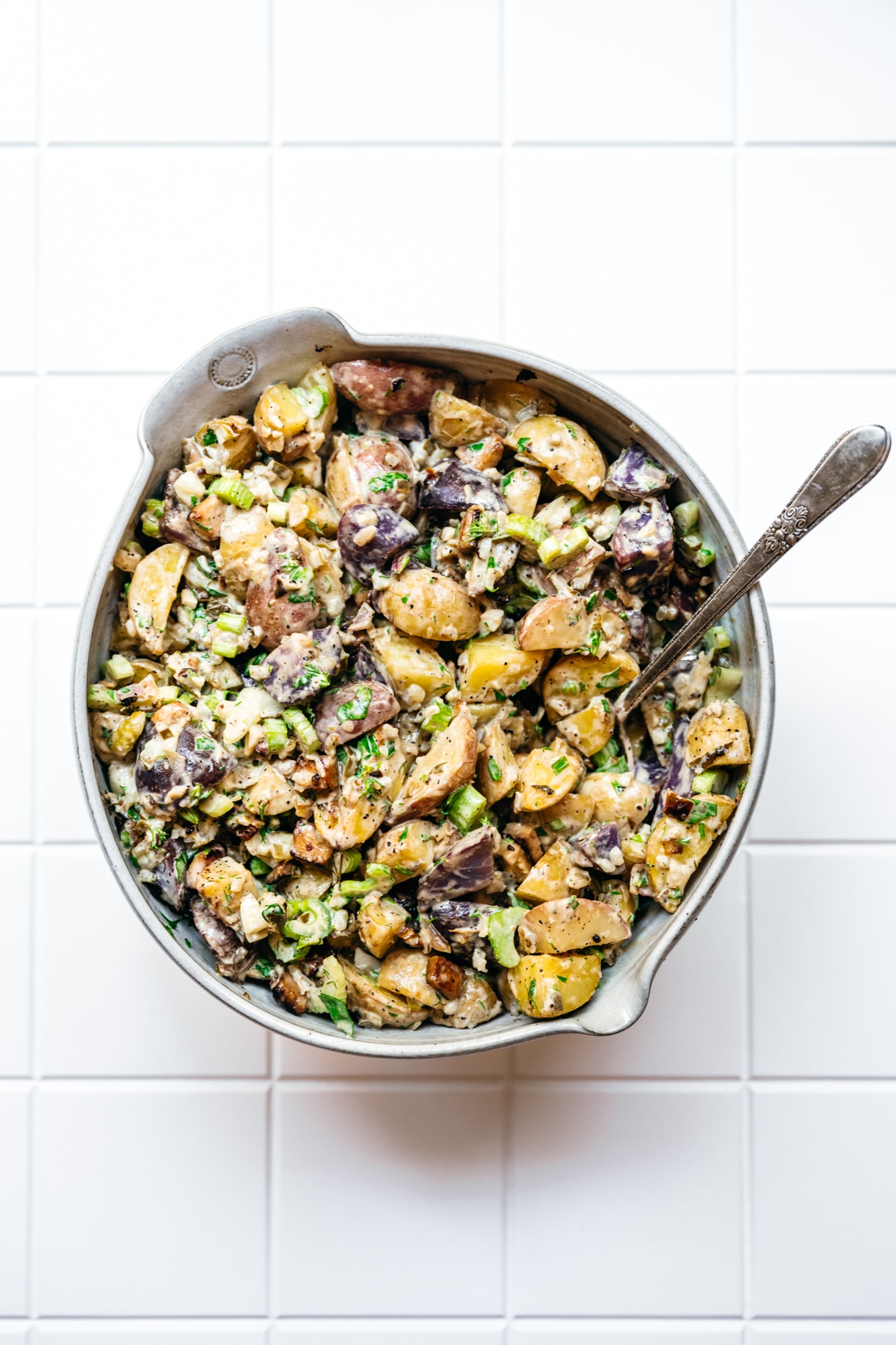 overhead view of vegan dill pickle potato salad in large white bowl