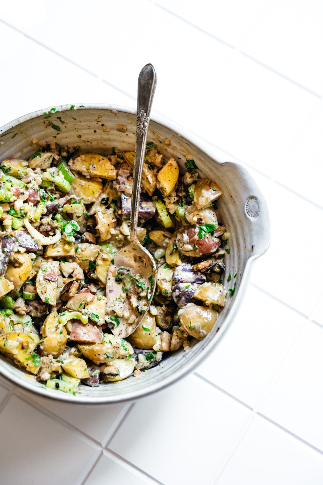 overhead view of vegan dill pickle potato salad in large white bowl