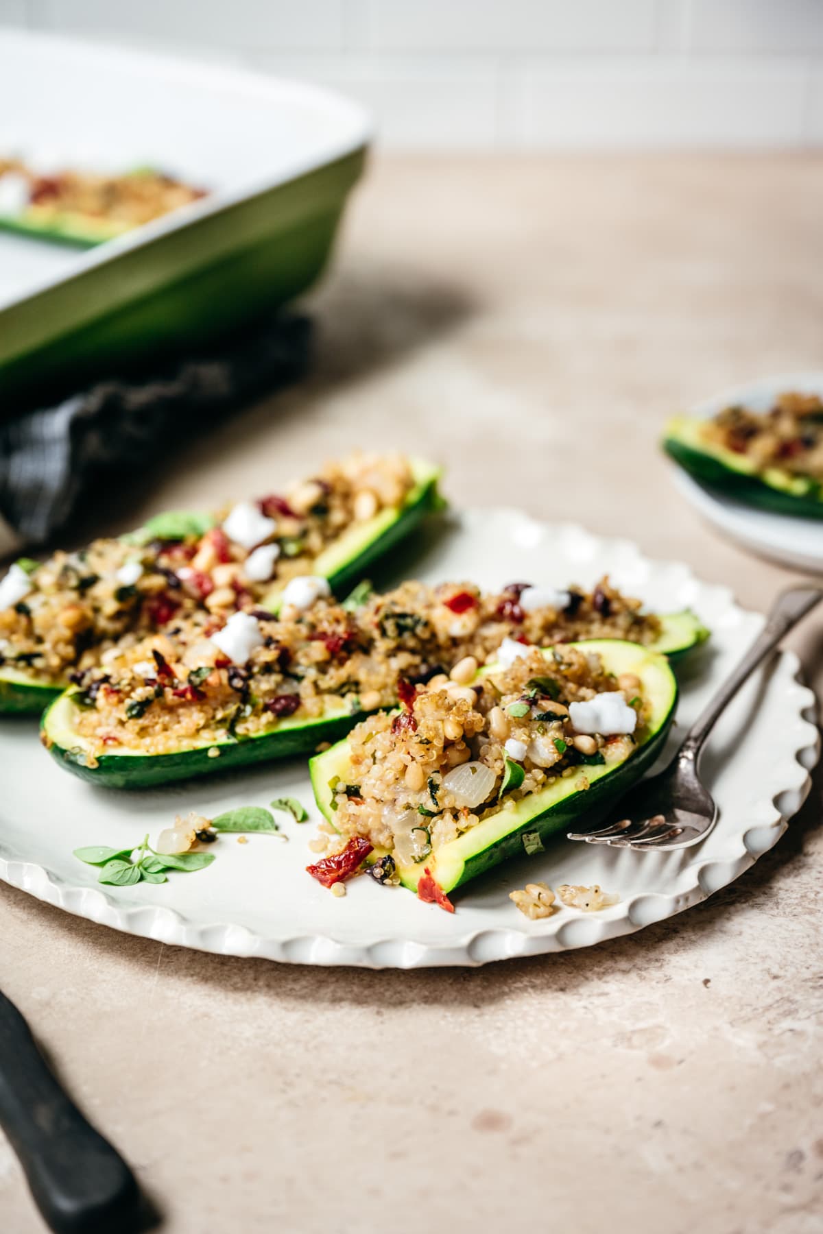 side view of mediterranean quinoa zucchini boat on plate cut in half