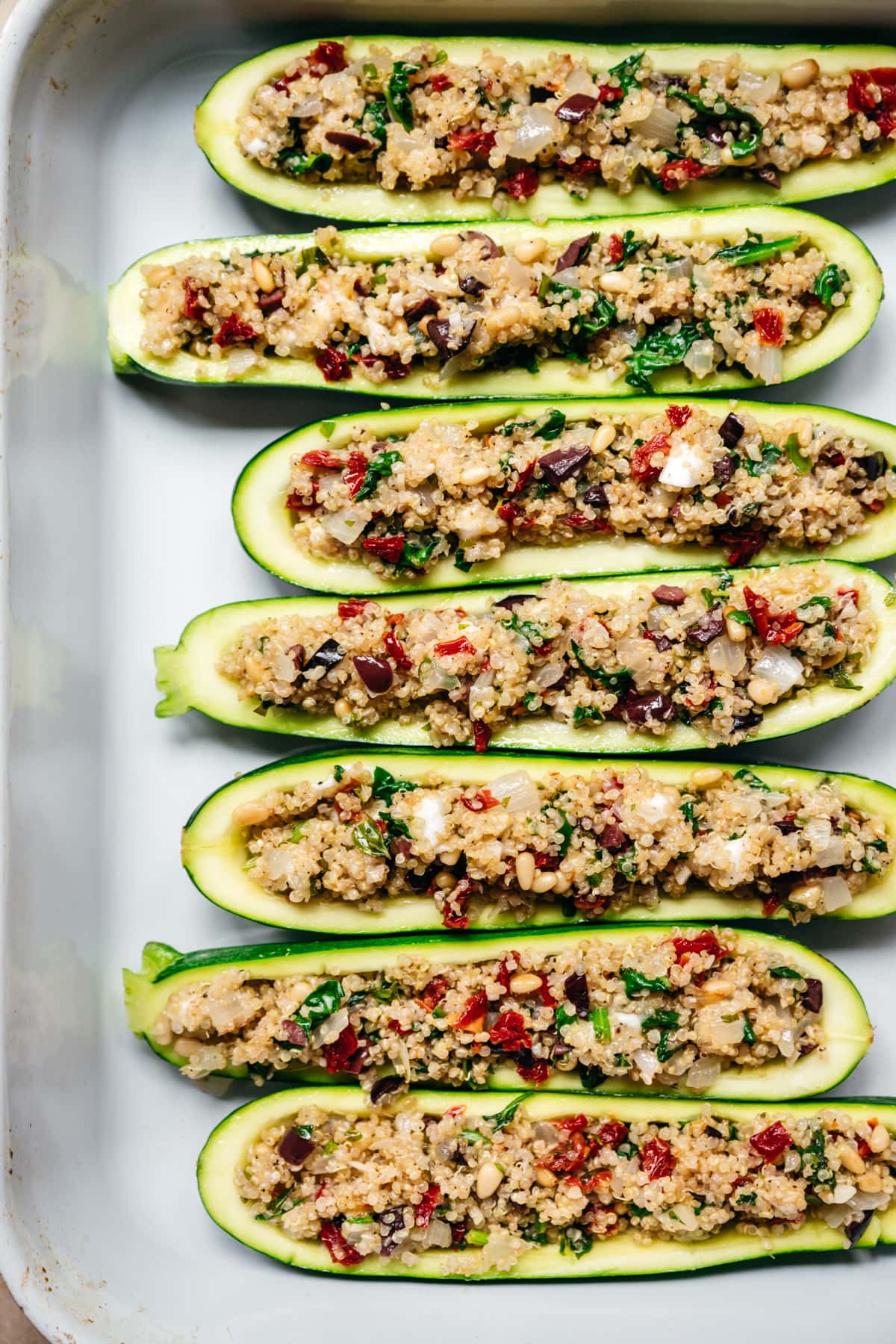 overhead view of quinoa stuffed zucchini boats in pan before baking