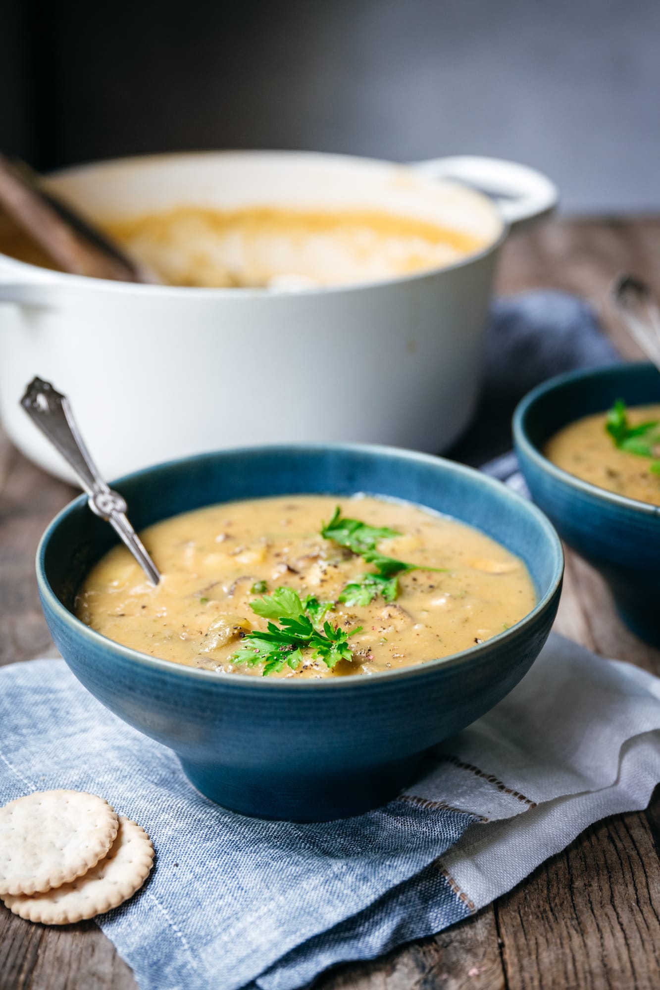 side view of vegan mushroom clam chowder in a blue bowl