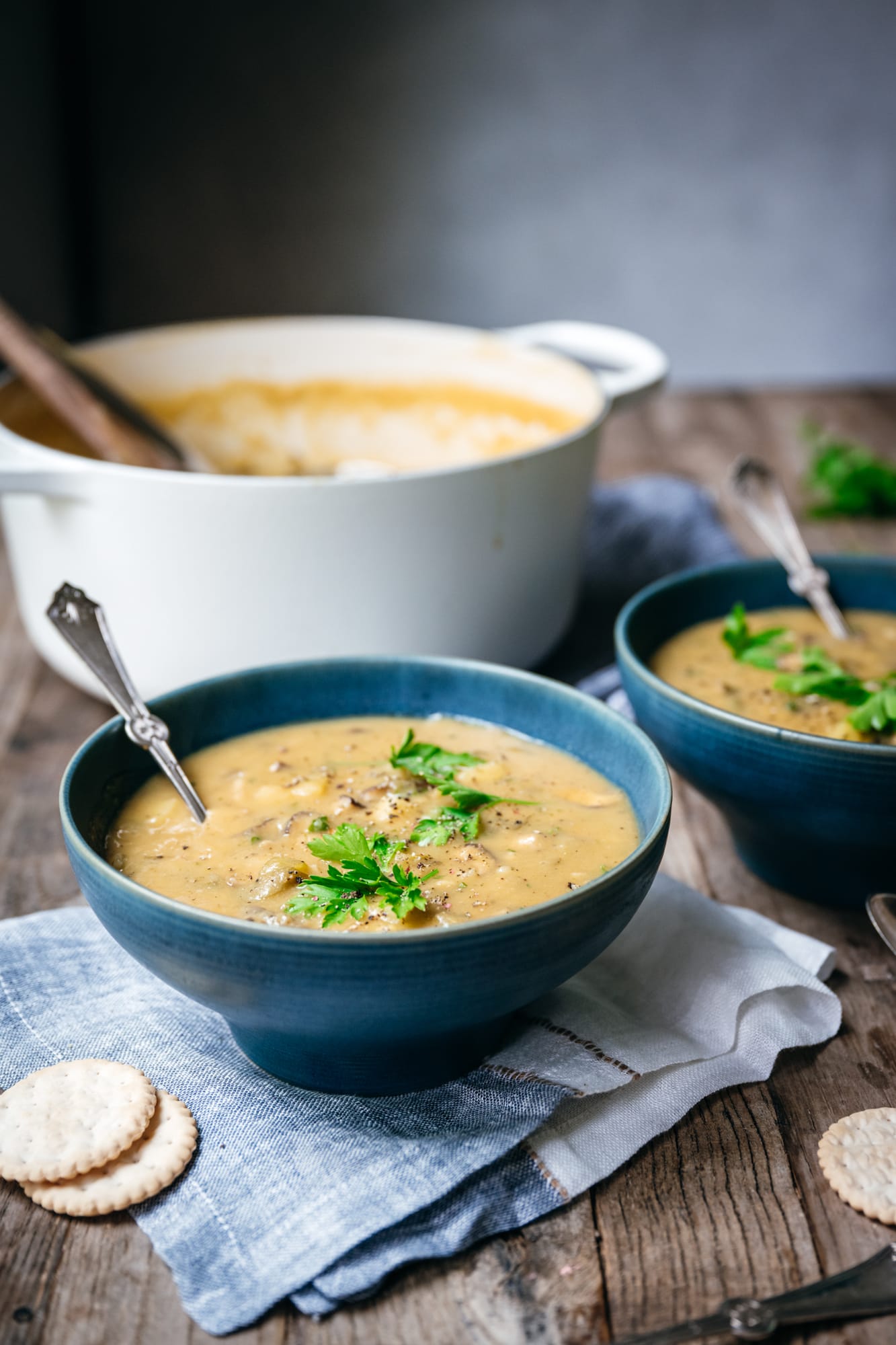 side view of vegan mushroom clam chowder in a blue bowl