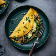 overhead view of vegan chickpea flour omelette on teal plate.