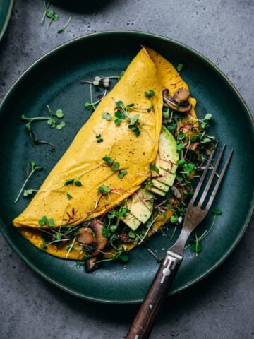 overhead view of vegan chickpea flour omelette on teal plate.