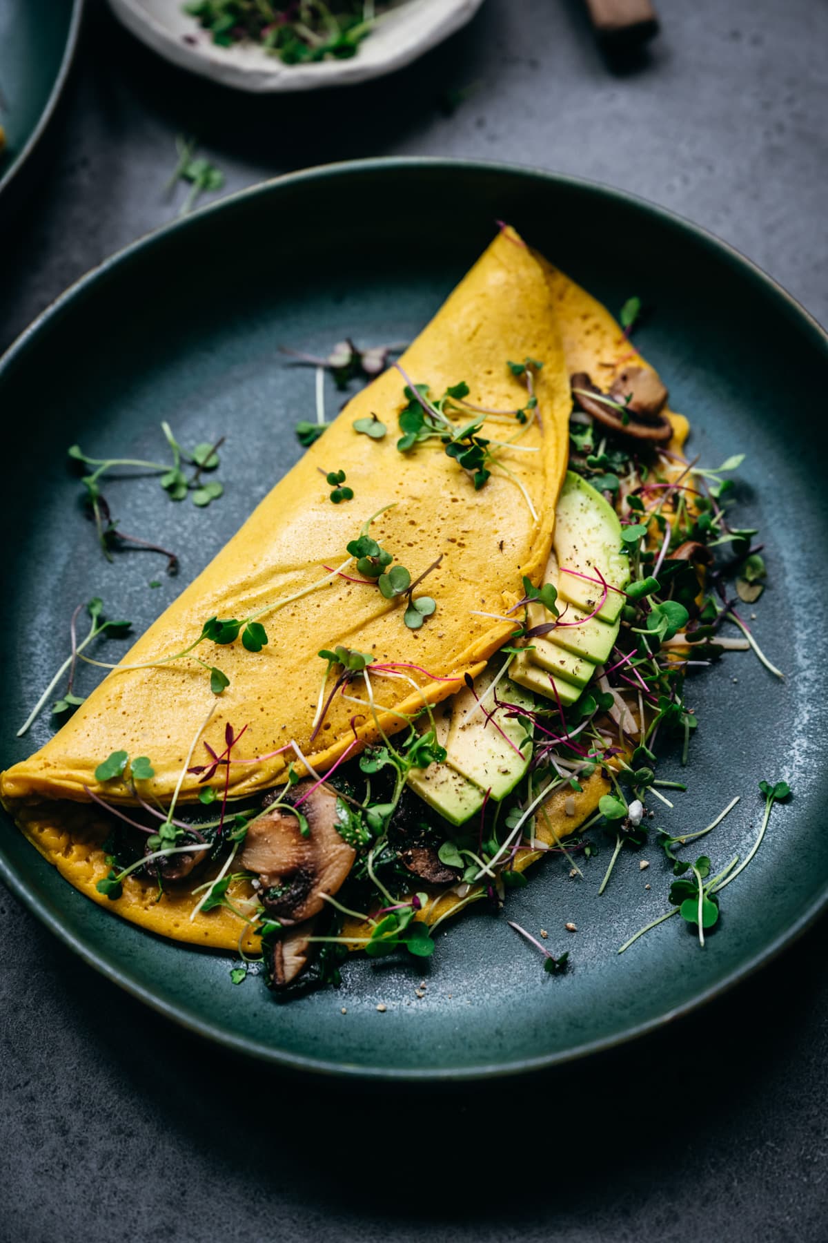 close up view of vegan omelette with mushrooms and avocado.