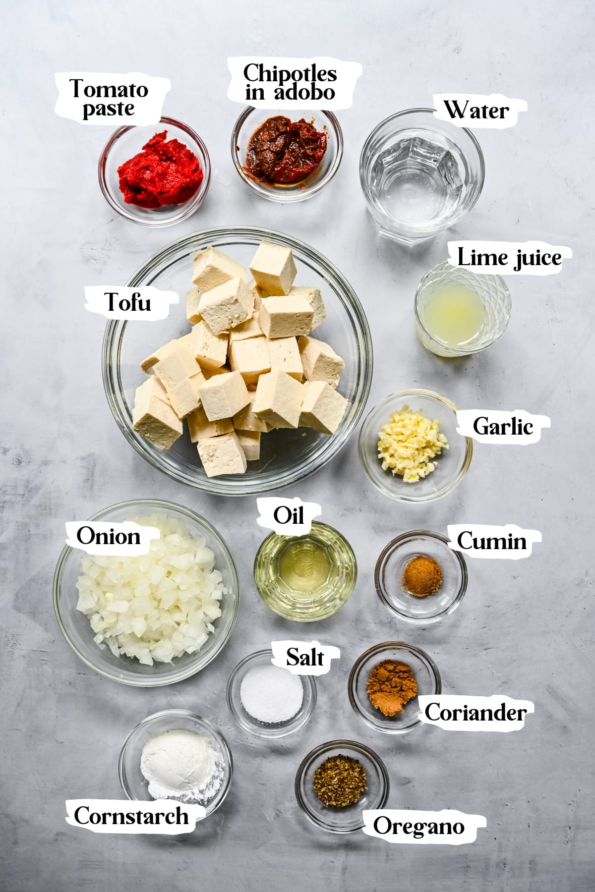 Overhead view of ingredients for sofritas tofu in small prep bowls. 