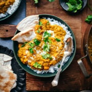 overhead view of bowl with white rice and vegan red lentil dal toped with fresh cilantro.