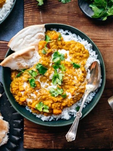 overhead view of bowl with white rice and vegan red lentil dal toped with fresh cilantro.