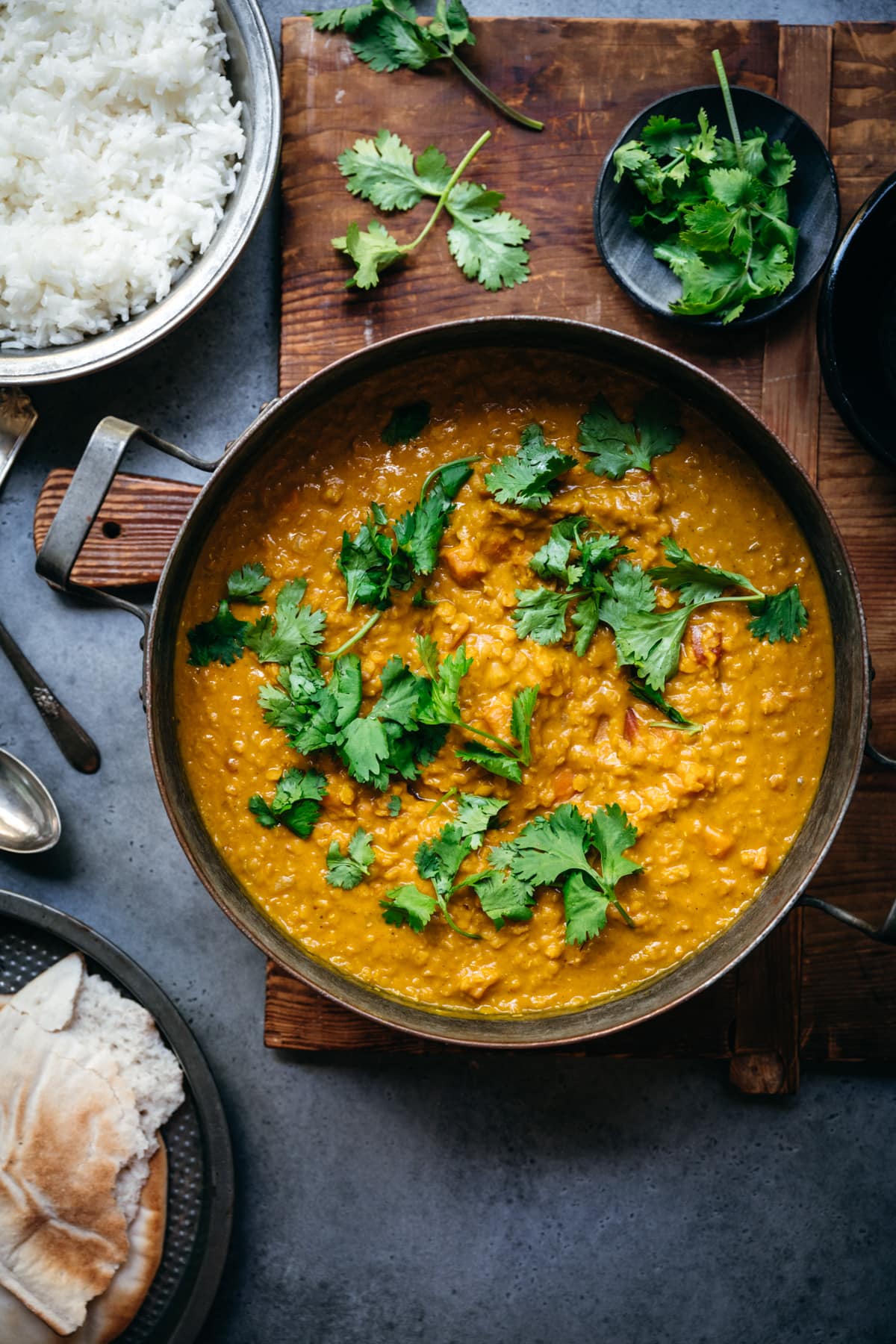 overhead view of a large pot of vegan masoor dal topped with fresh cilantro.